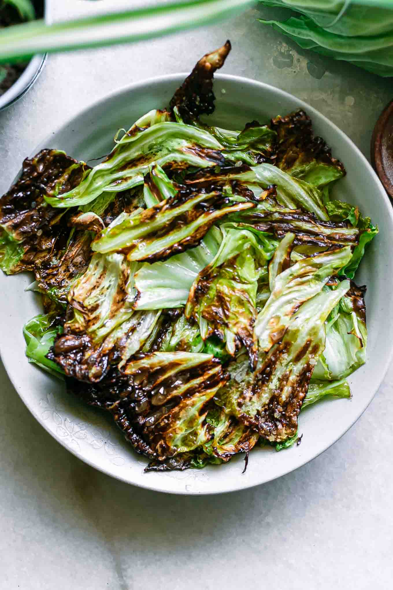 baked cabbage chips on a blue plate on a white table