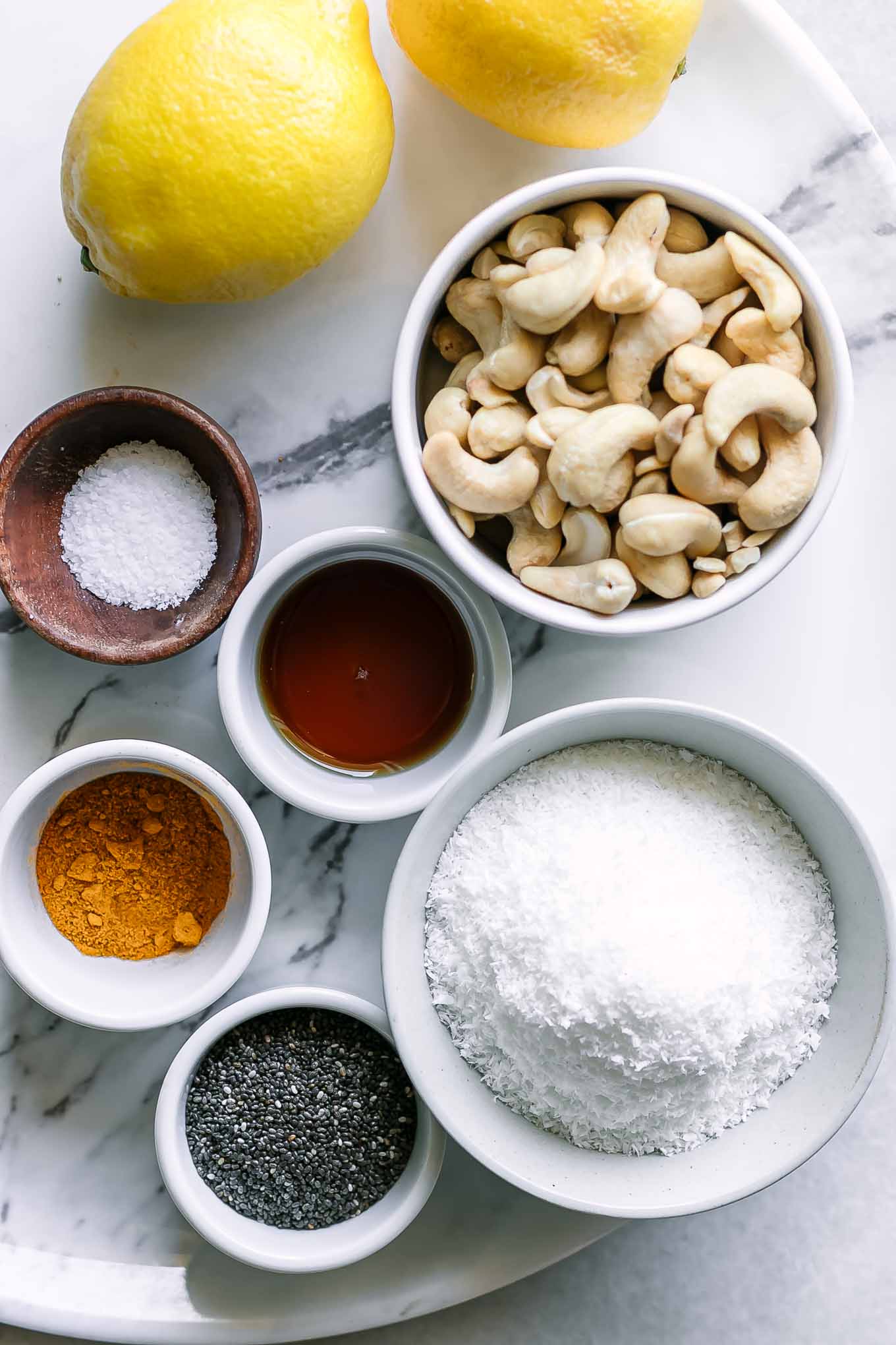 bowls of coconut flakes, lemons, cashews, chia seeds, salt, and maple syrup for energy balls