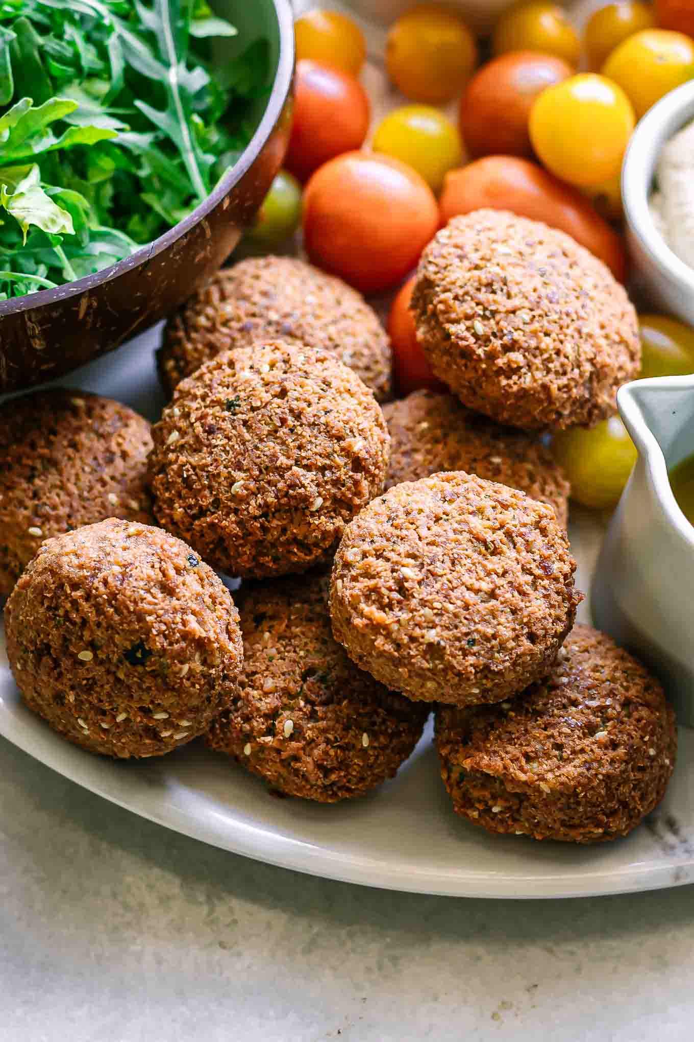 falafel on a plate with arugula and tomatoes