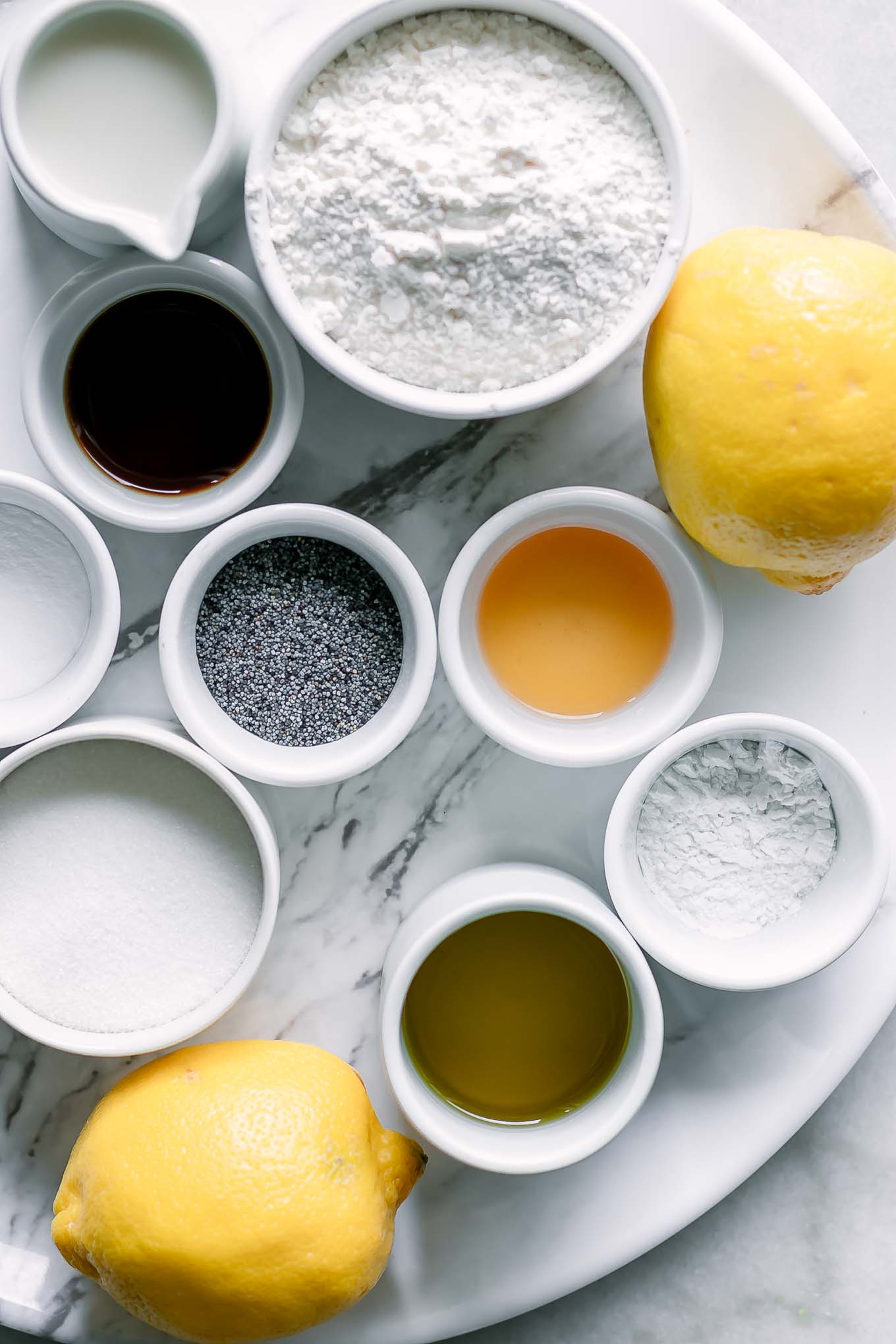 bowls of flour, lemon zest, poppyseeds, baking soda, baking powder, and other ingredients for muffins