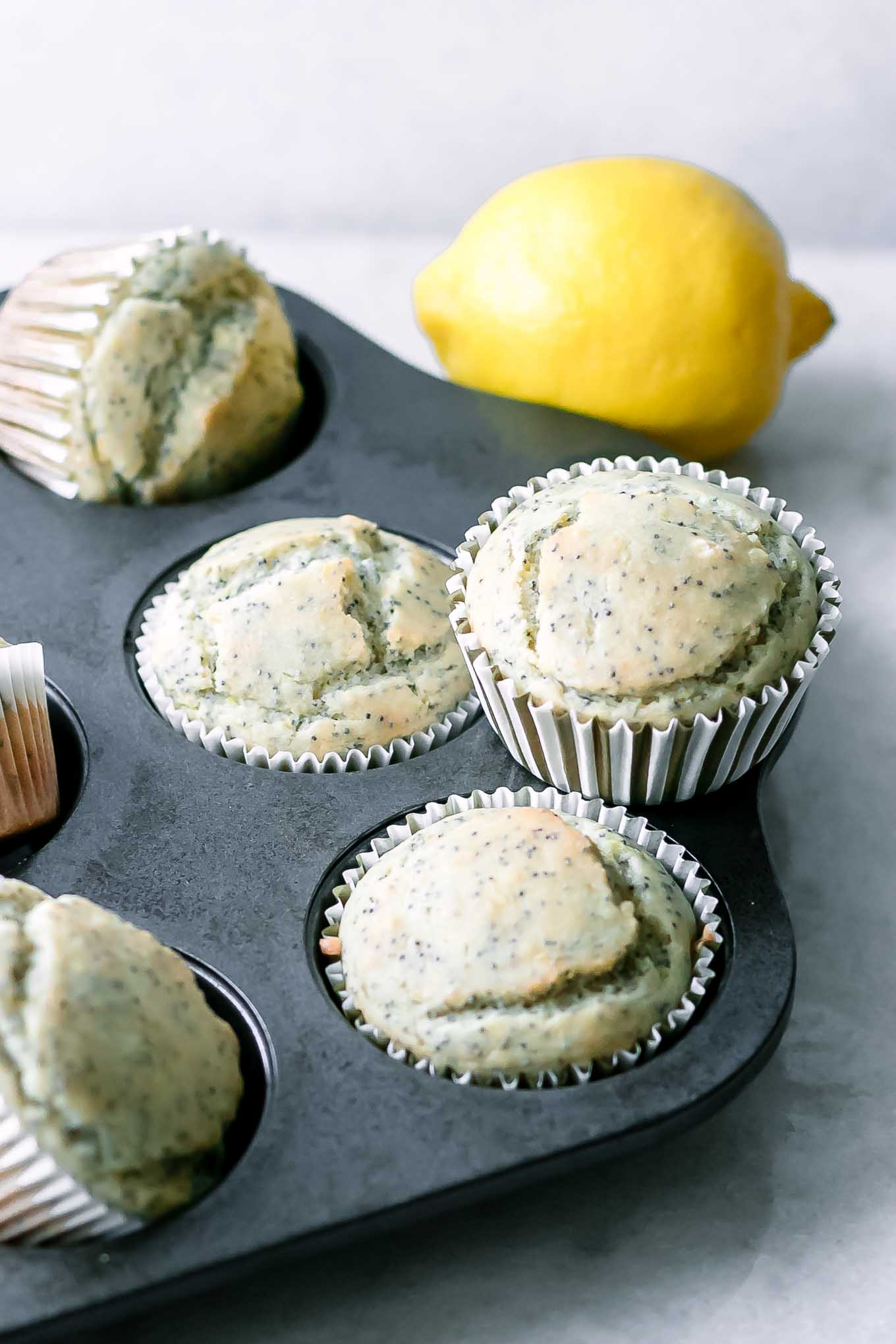 a muffin tin with lemon poppyseed muffins after baking