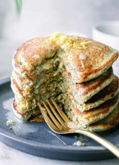 a stack of lemon poppyseed pancakes with a fork on a blue plate