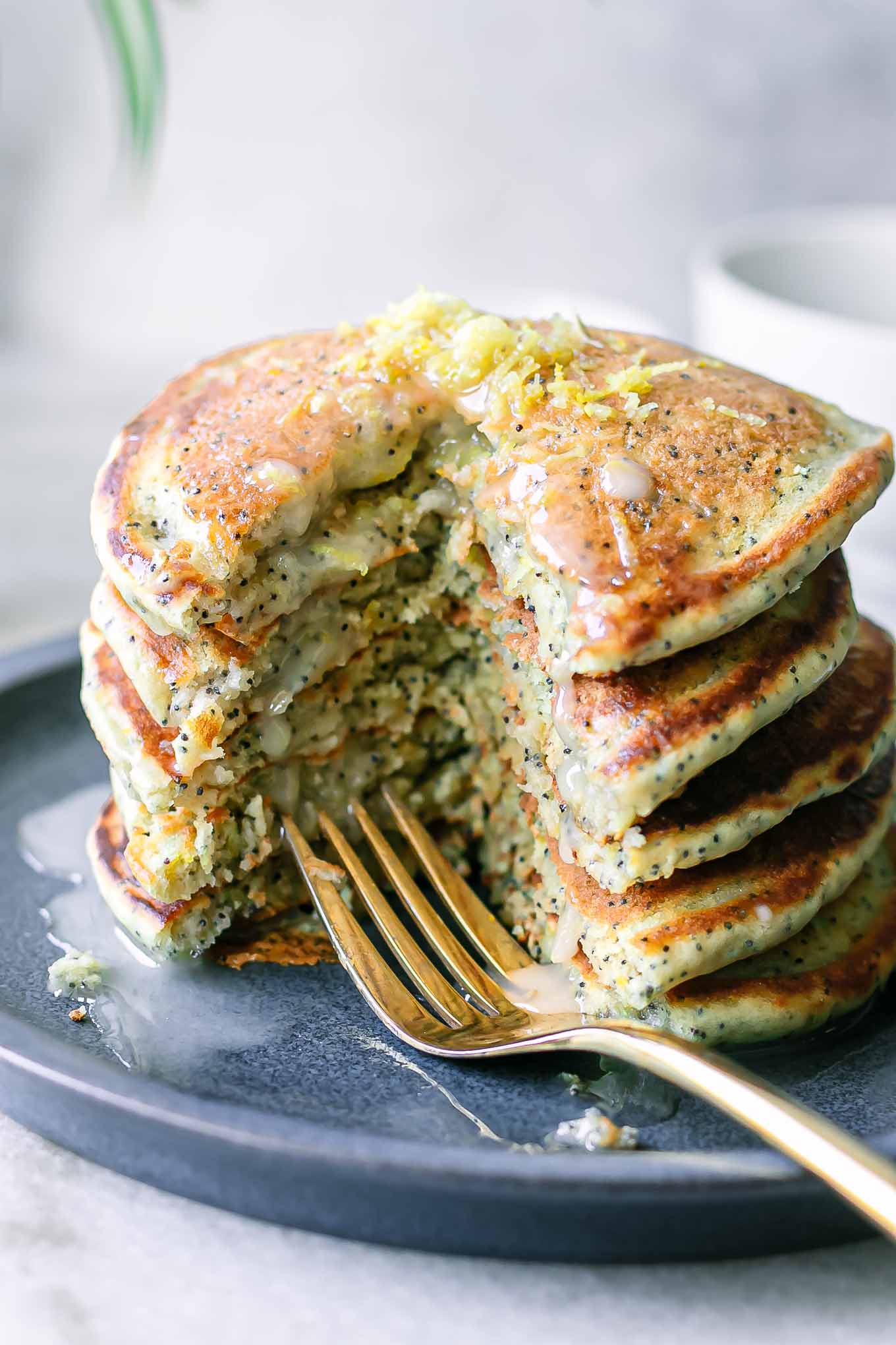 a stack of lemon poppyseed pancakes with a fork on a blue plate