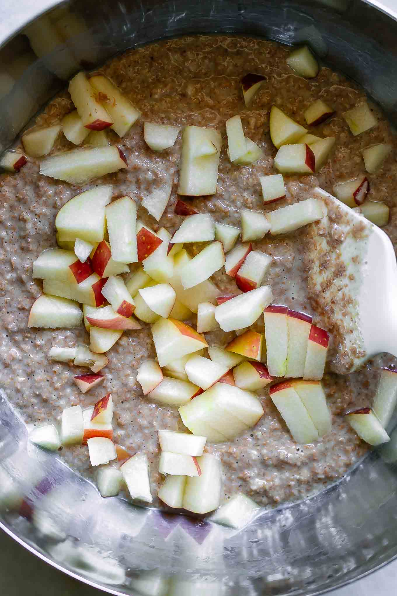 chopped apples stirring into a bran muffin batter
