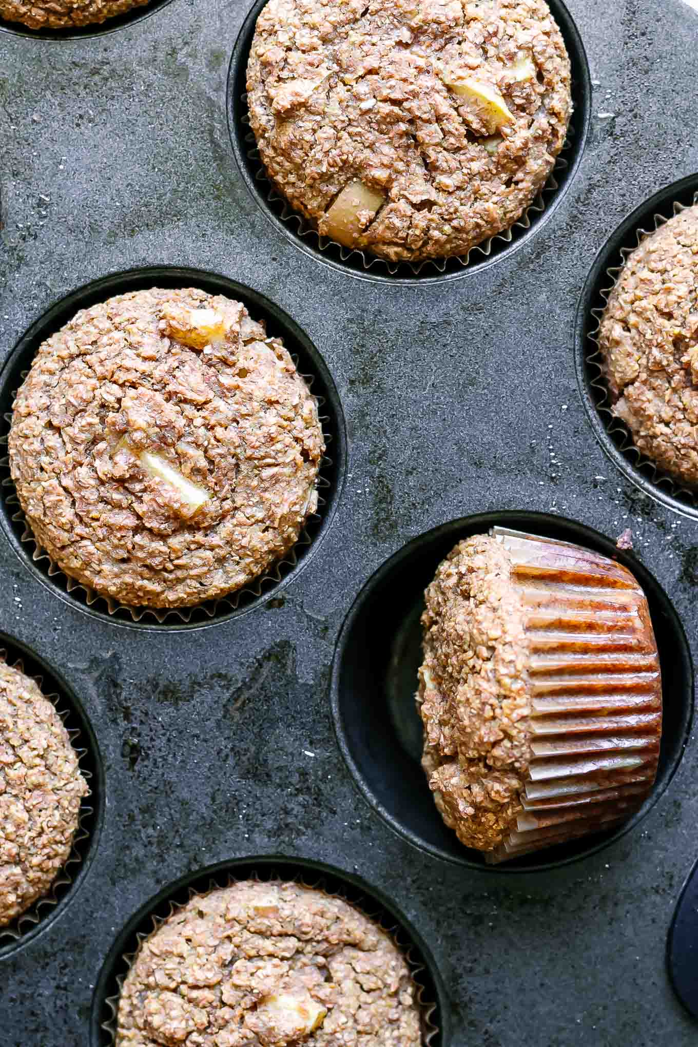 bran muffins with apples in a muffin tin after baking