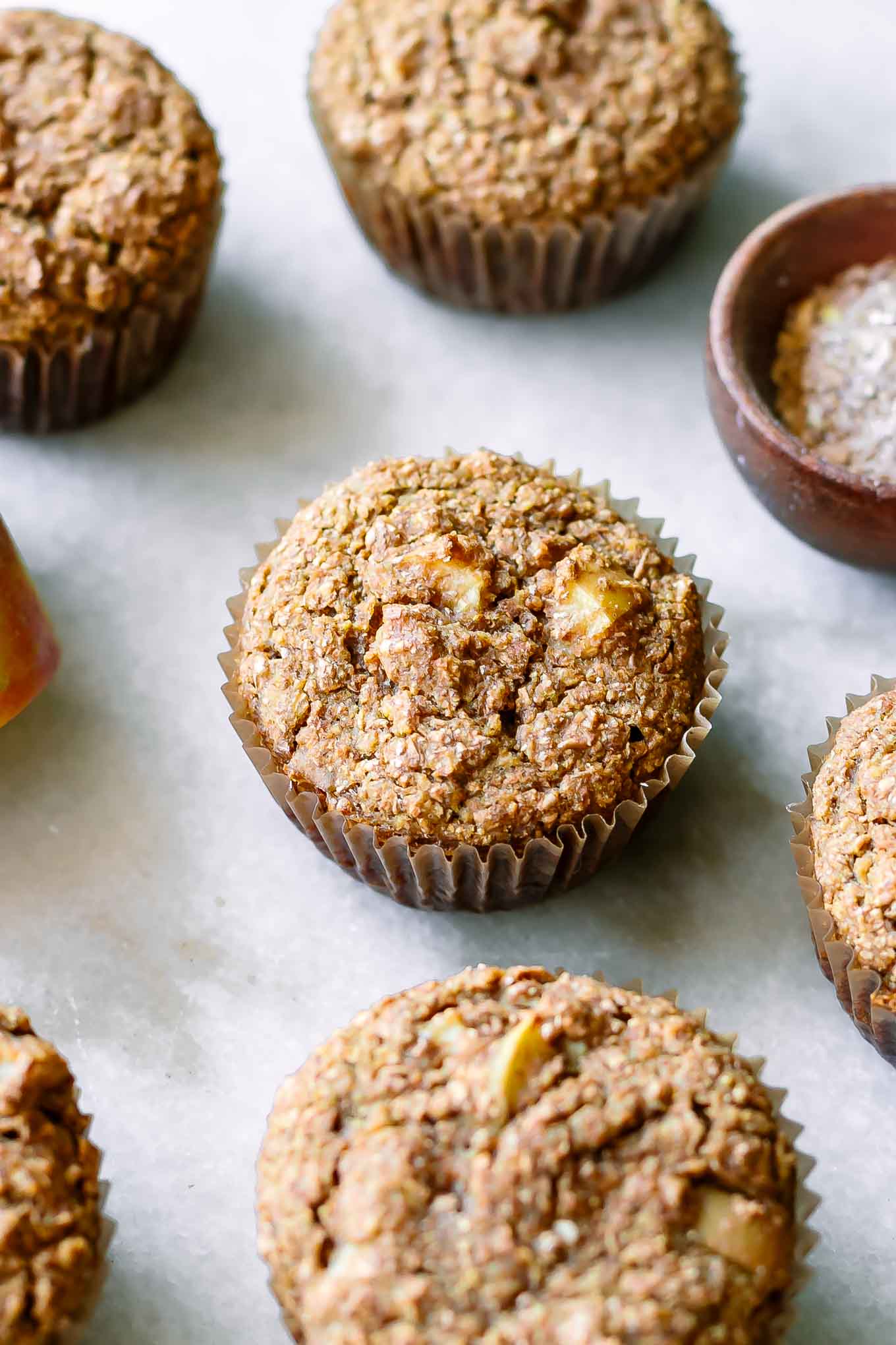 bran muffins with apples on a white countertop