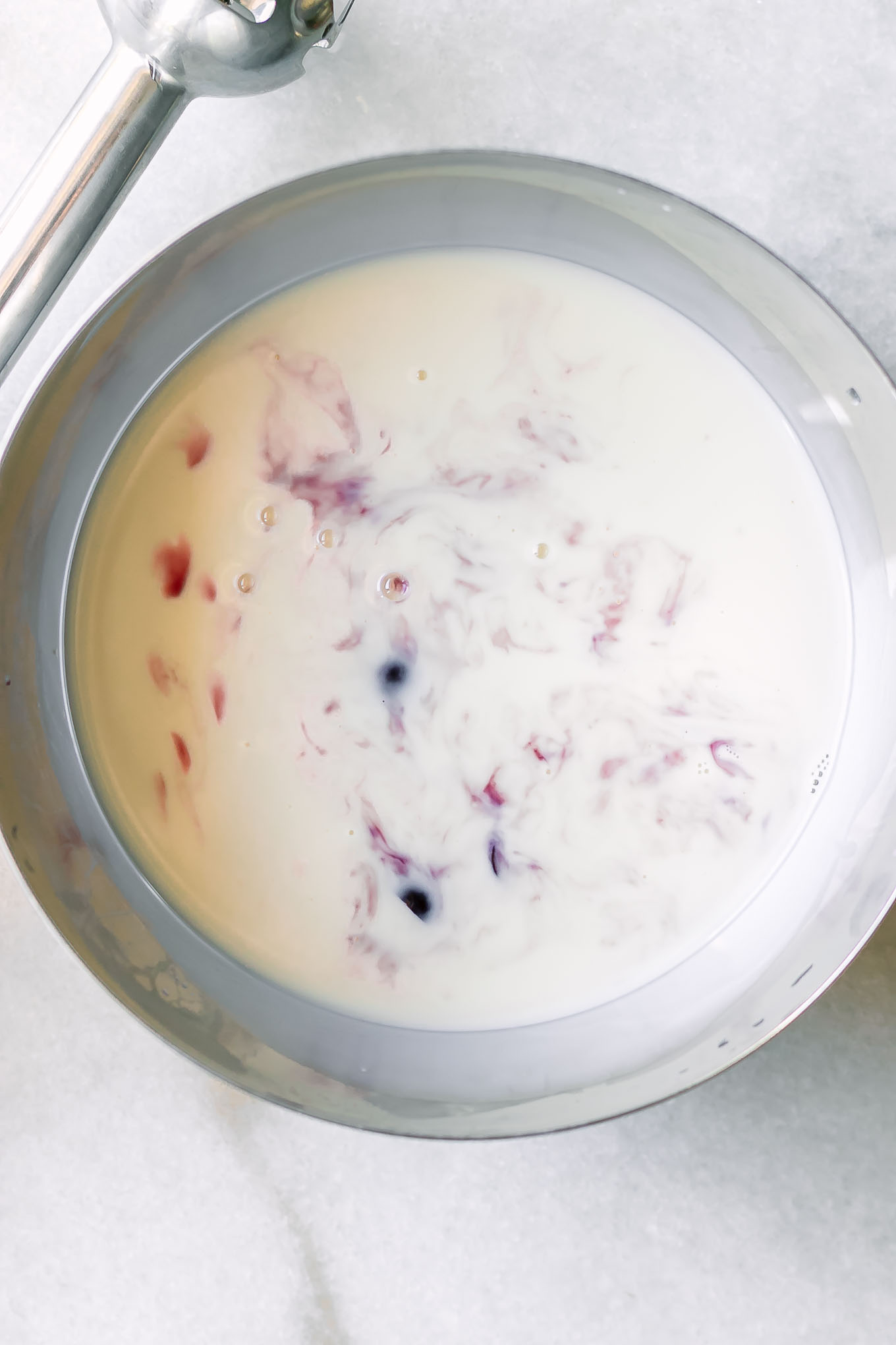 a bowl of milk with cut cherries before blending for chia pudding