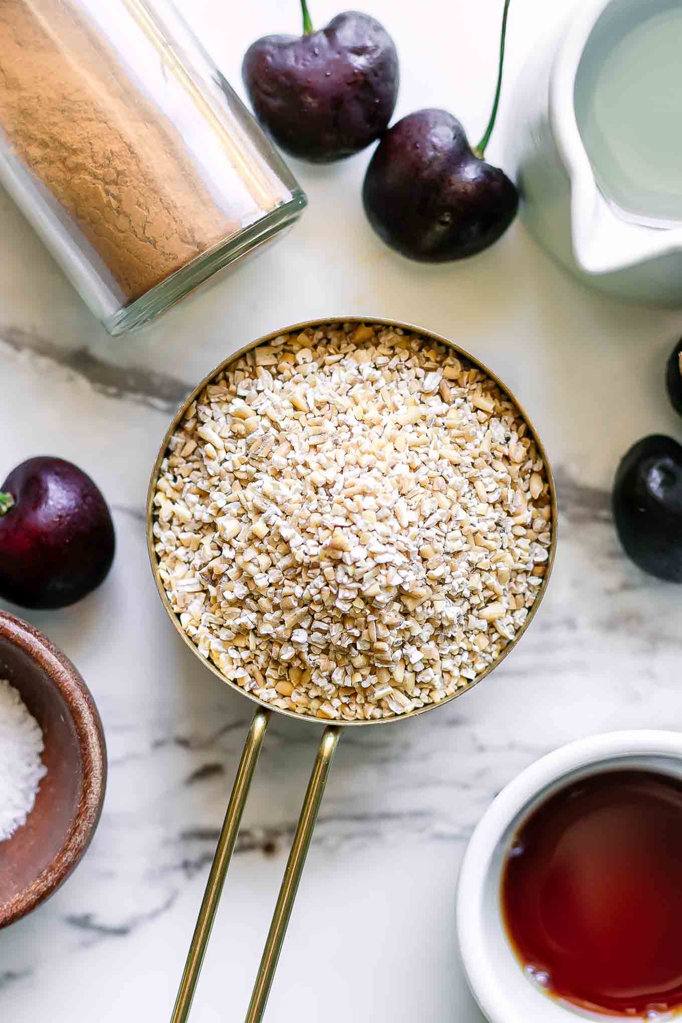 bowls of oatmeal, water, cinnamon, and fresh cherries for cherry oatmeal