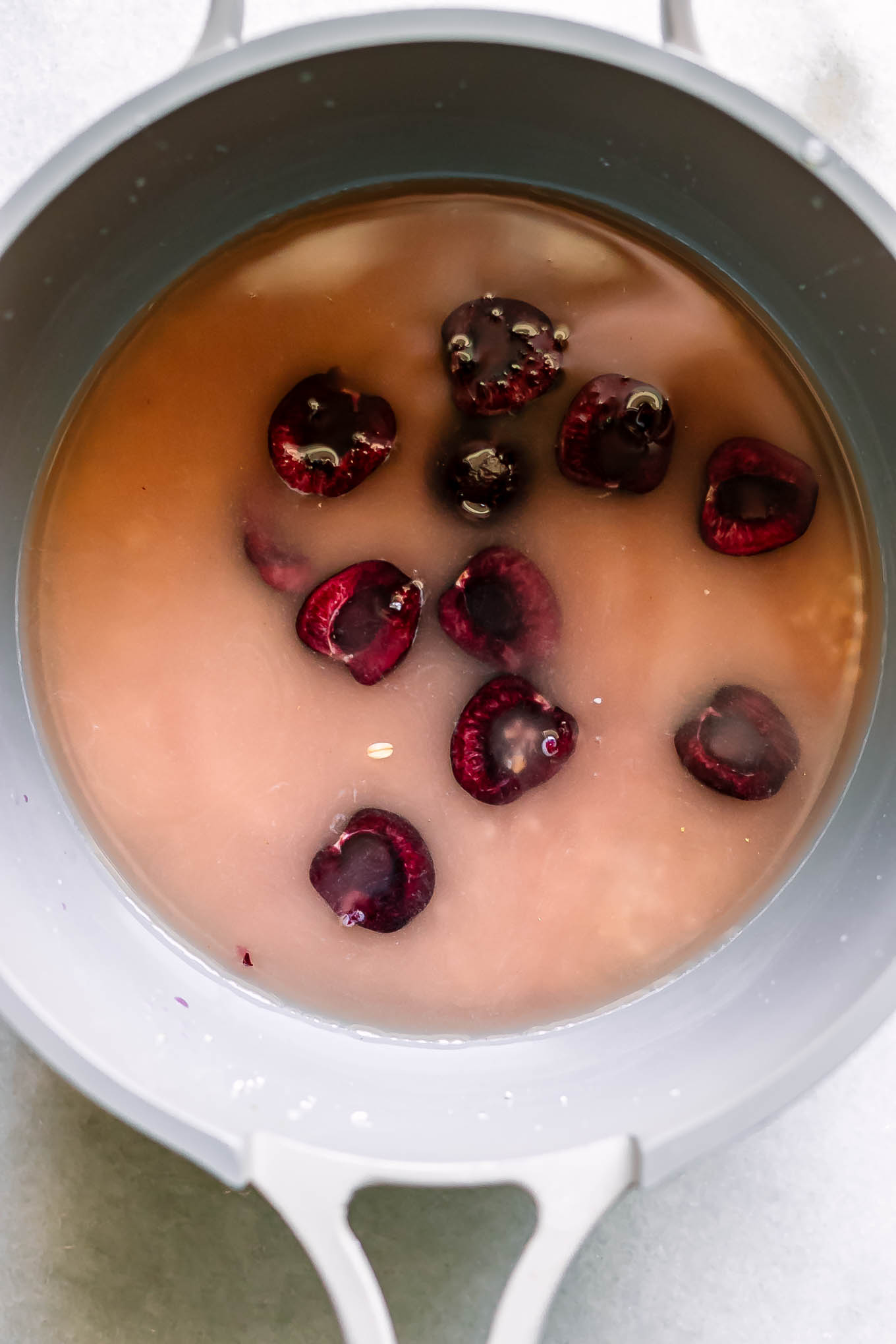 a small pot with oats, water, and sliced cherries before cooking
