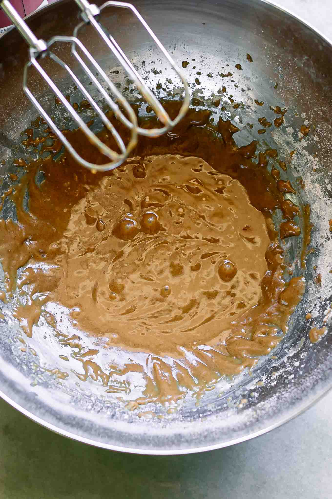 a metal mixing bowl with flour mixed into vegan butter, brown sugar, and vanilla