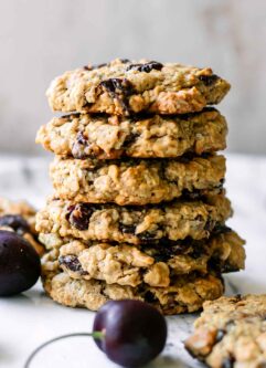 a stack of vegan oatmeal cookies with dried cranberries on a white table