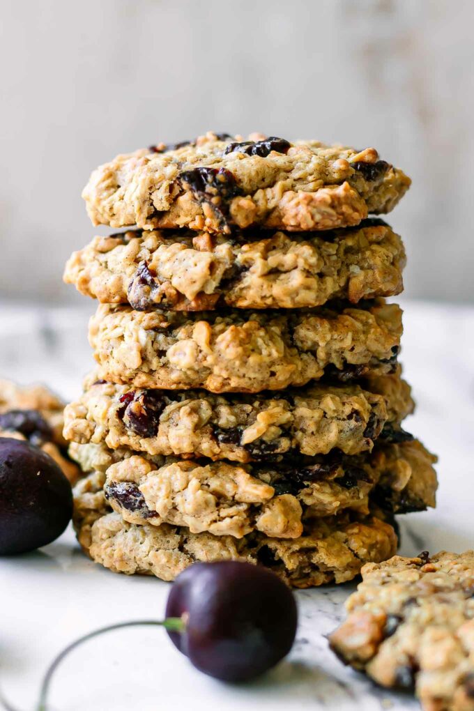 a stack of vegan oatmeal cookies with dried cranberries on a white table