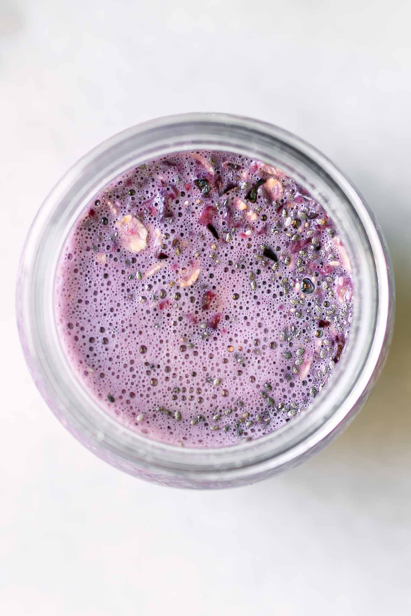 a close up photo of cherry overnight oats inside a jar before refrigerating