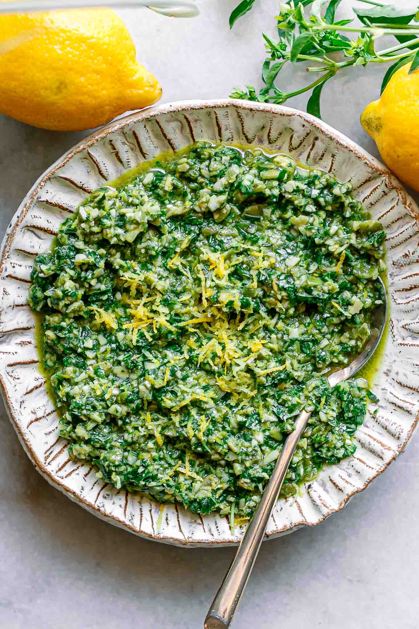 lemon basil pesto on a white plate with lemon zest as garnish