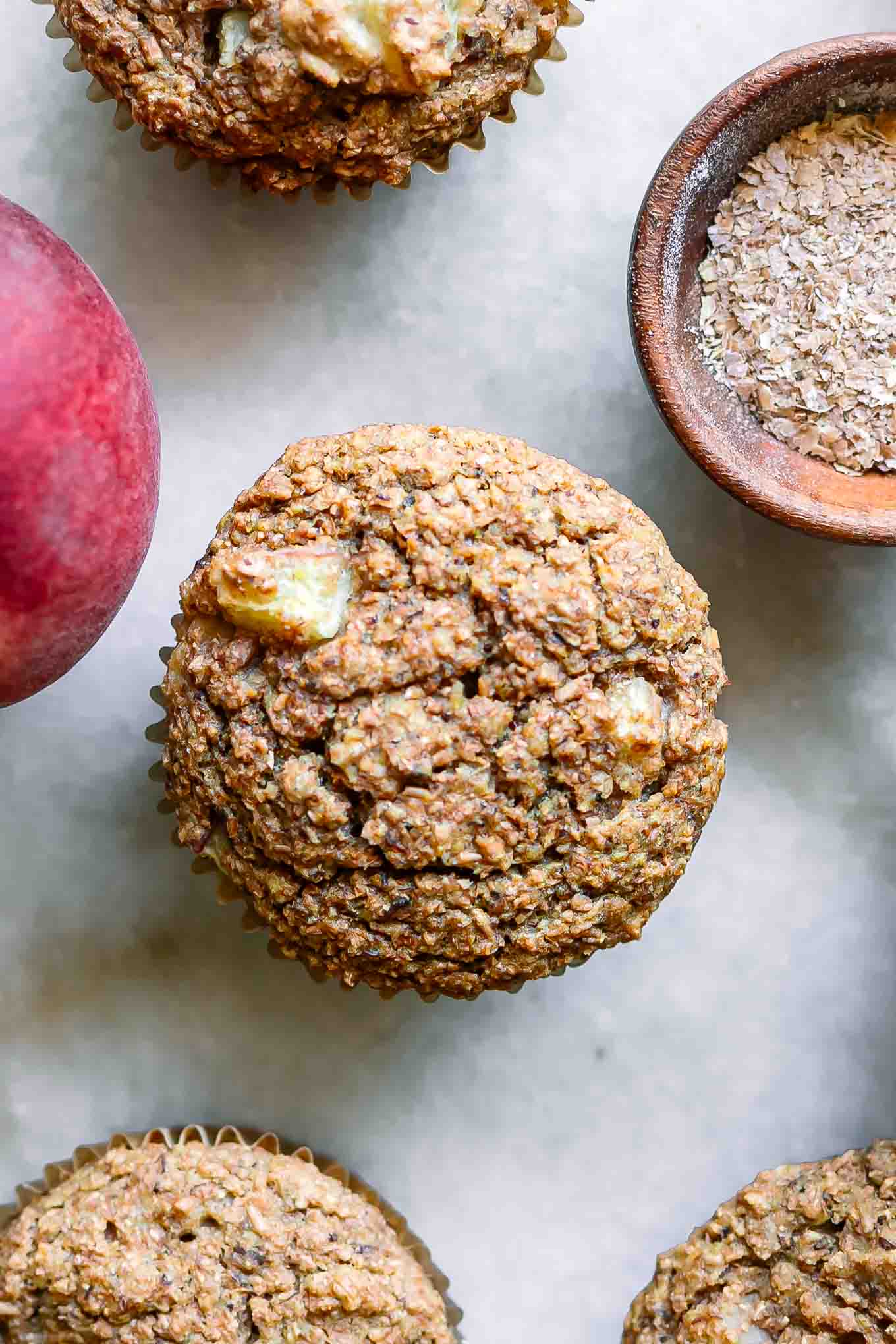 a close up photo of a peach bran muffin on a white table