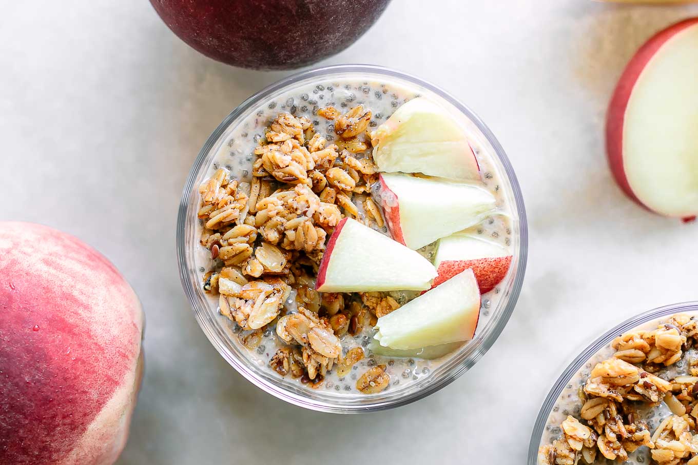 a bowl of peach chia seed pudding with granola and sliced peaches as garnish 