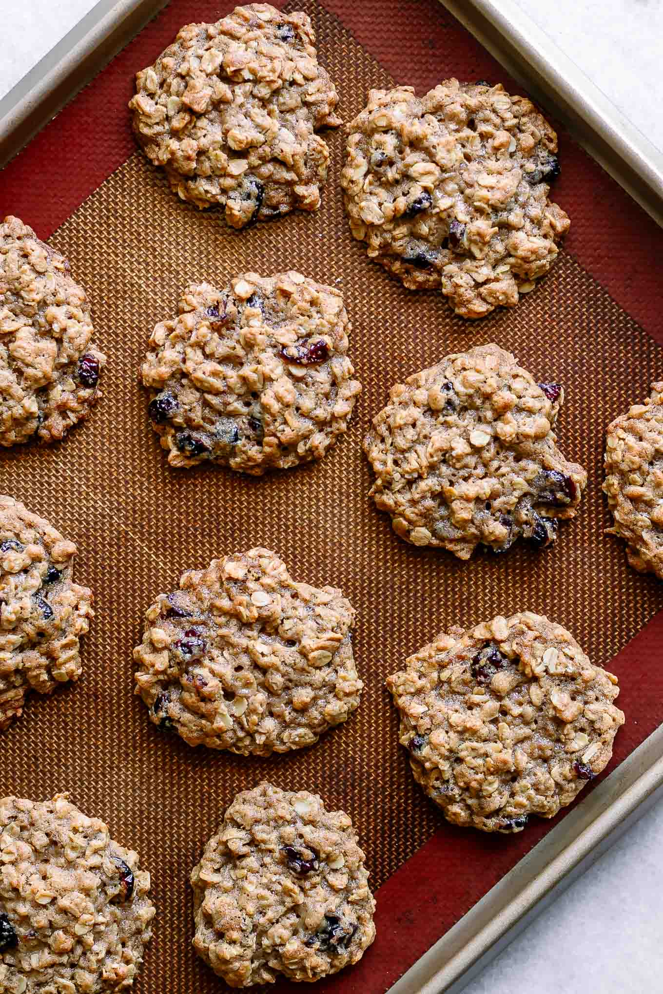 a baking sheet with plant-based cranberry oatmeal cookies after baking