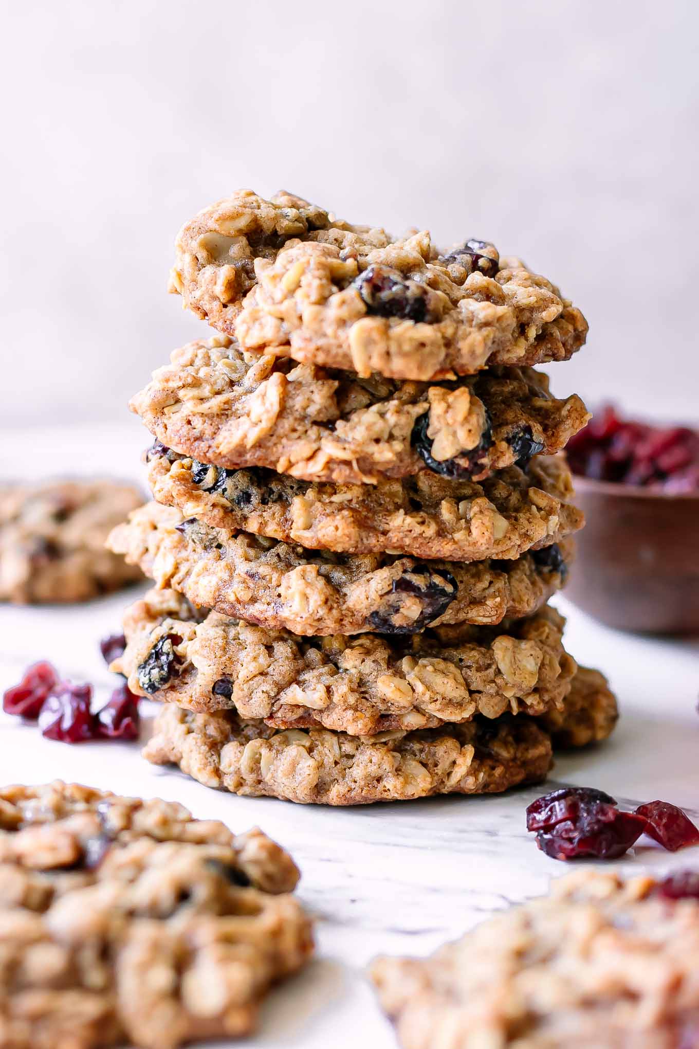 stacked oatmeal cookies with cranberries on a white table