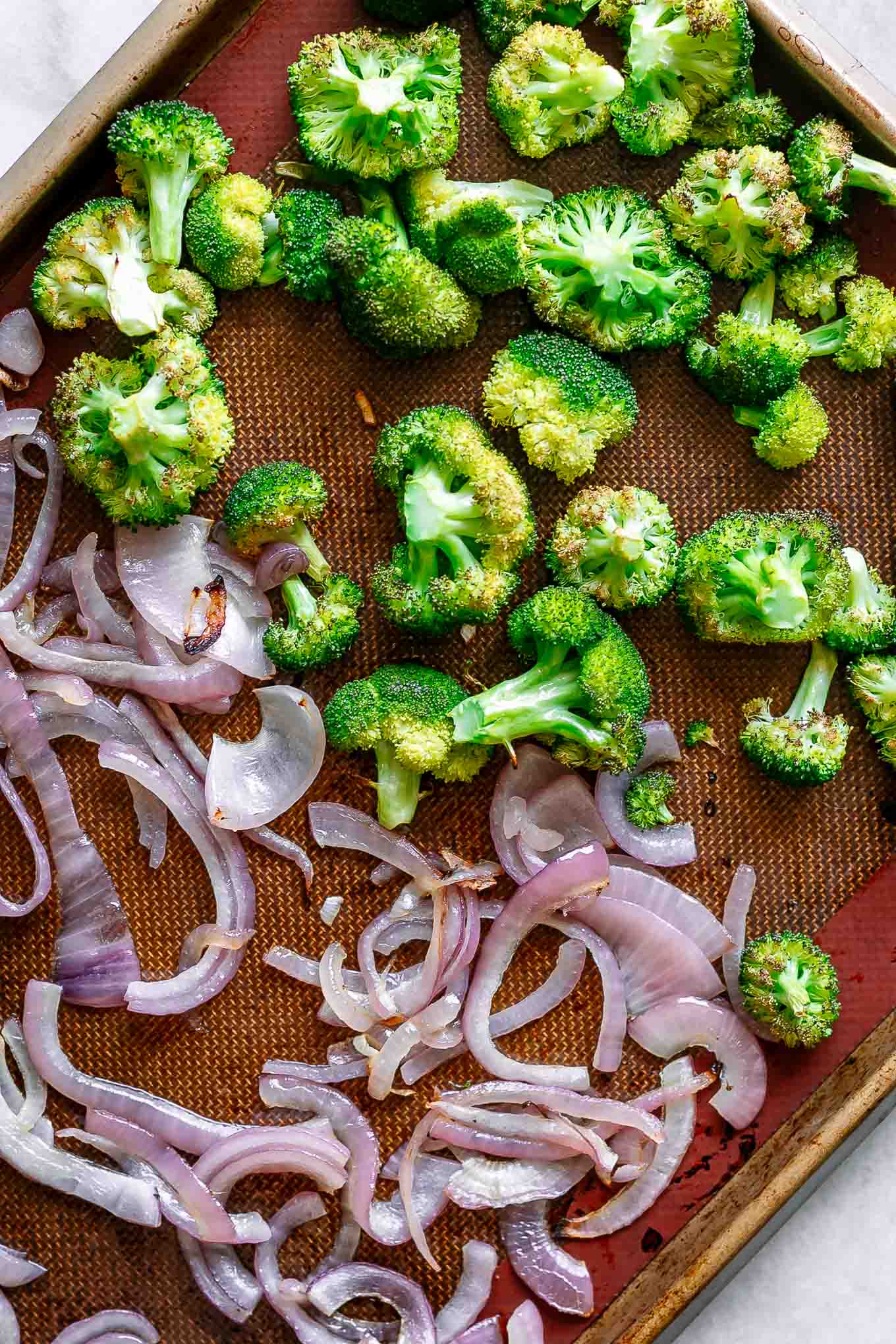 baked onions and broccoli on a baking sheets