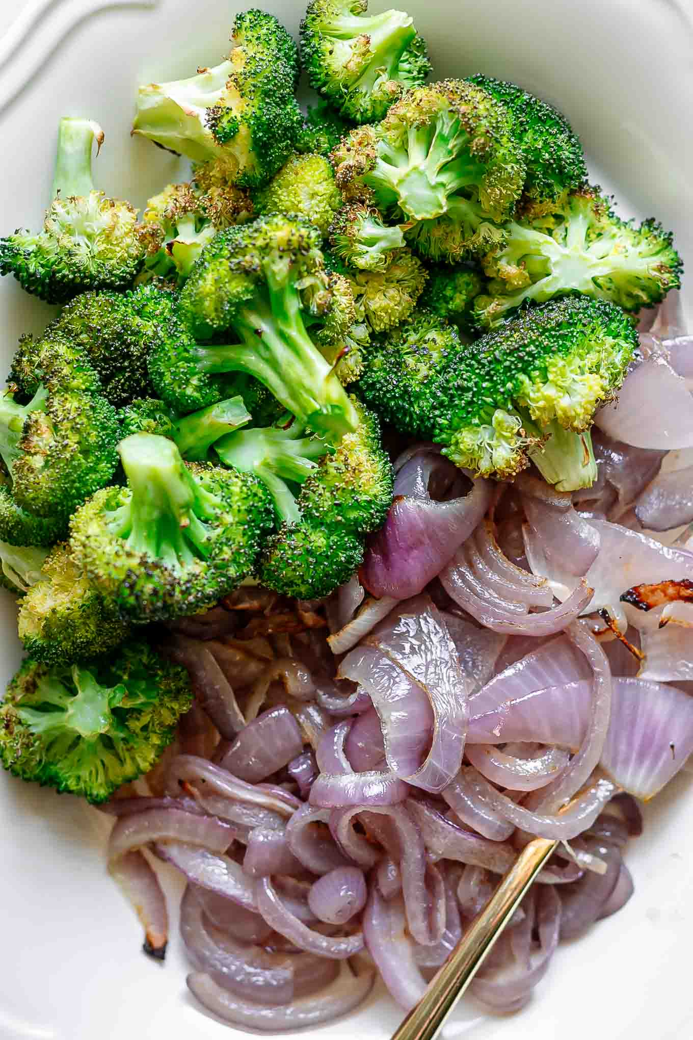 a close up photos of a side dish with baked onions and broccoli