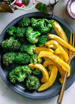 roasted acorn squash and broccoli on a blue side dish with a gold fork