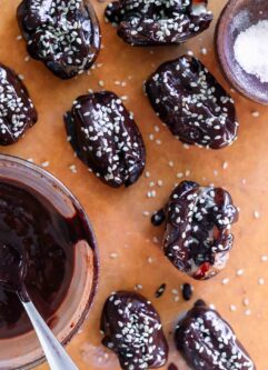 tahini dates with melted chocolate on a wood cutting board