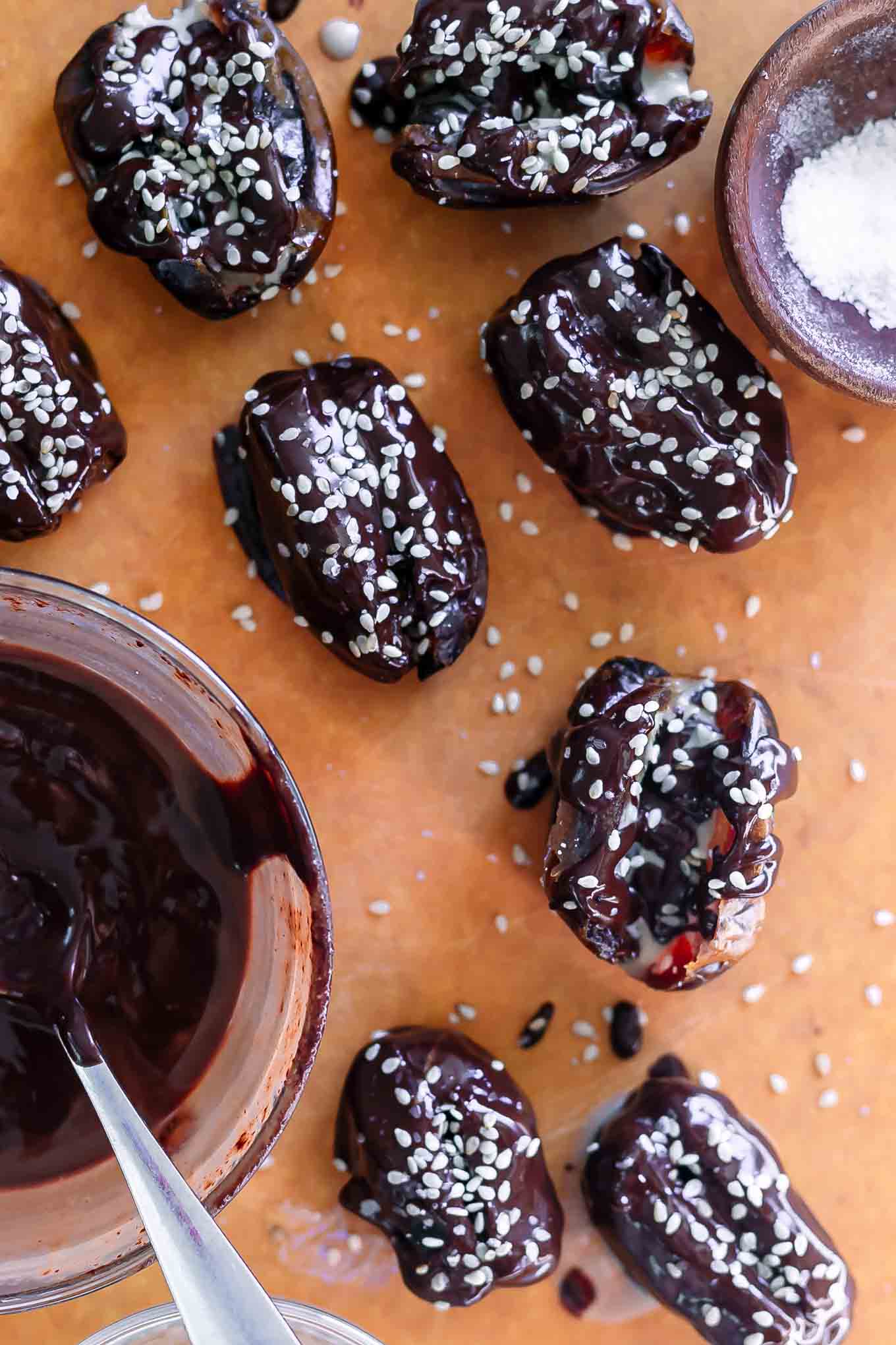 tahini dates with melted chocolate on a wood cutting board