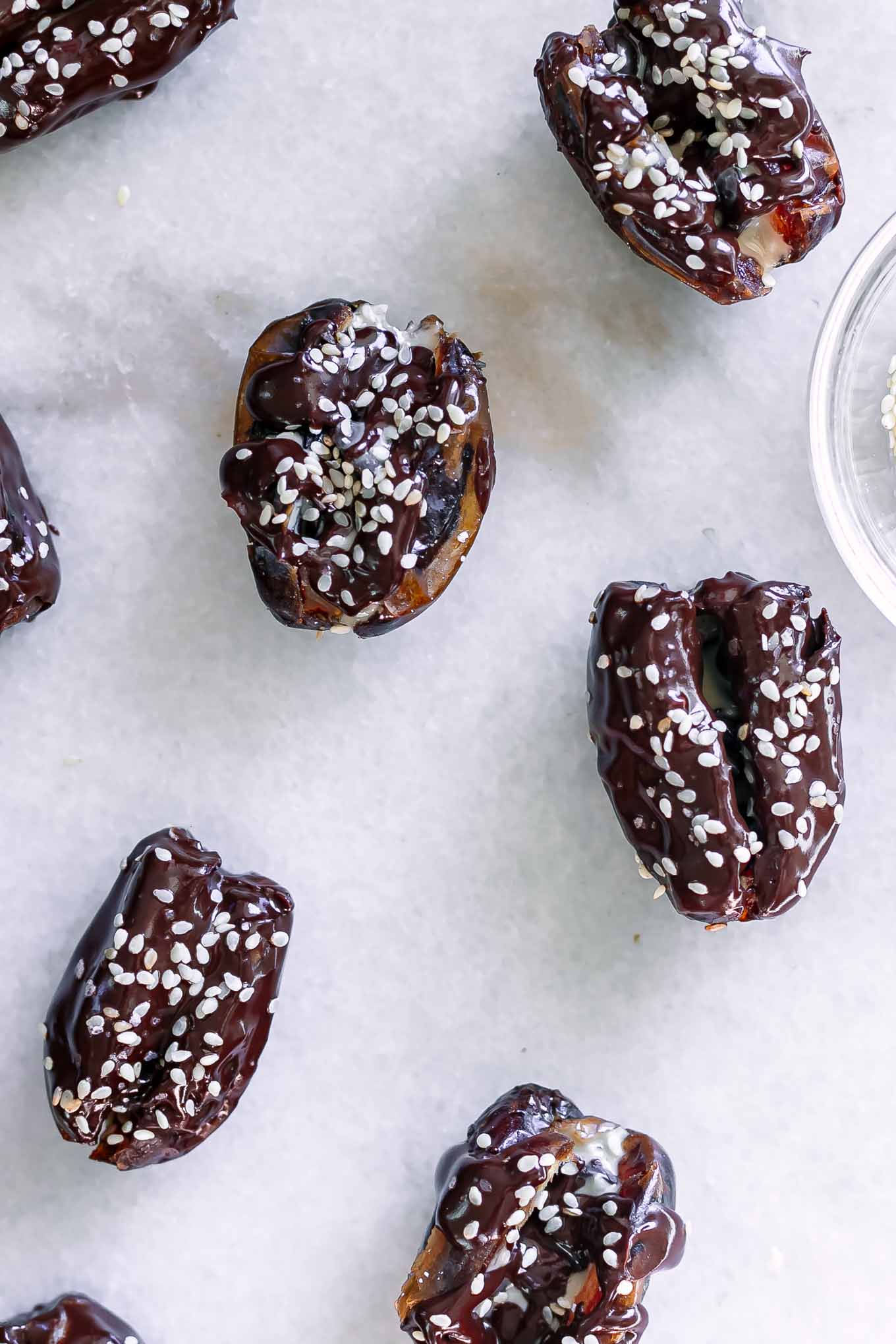 dates stuffed with tahini and drizzed with chocolate on a white table
