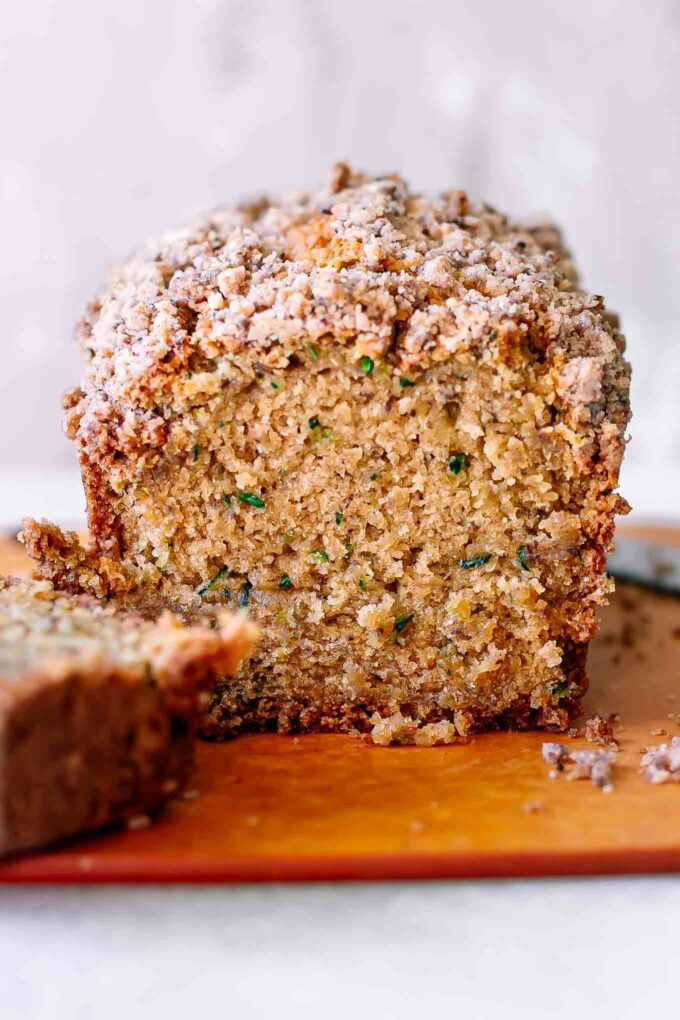 a loaf of plant-based zucchini bread sliced on a cutting board
