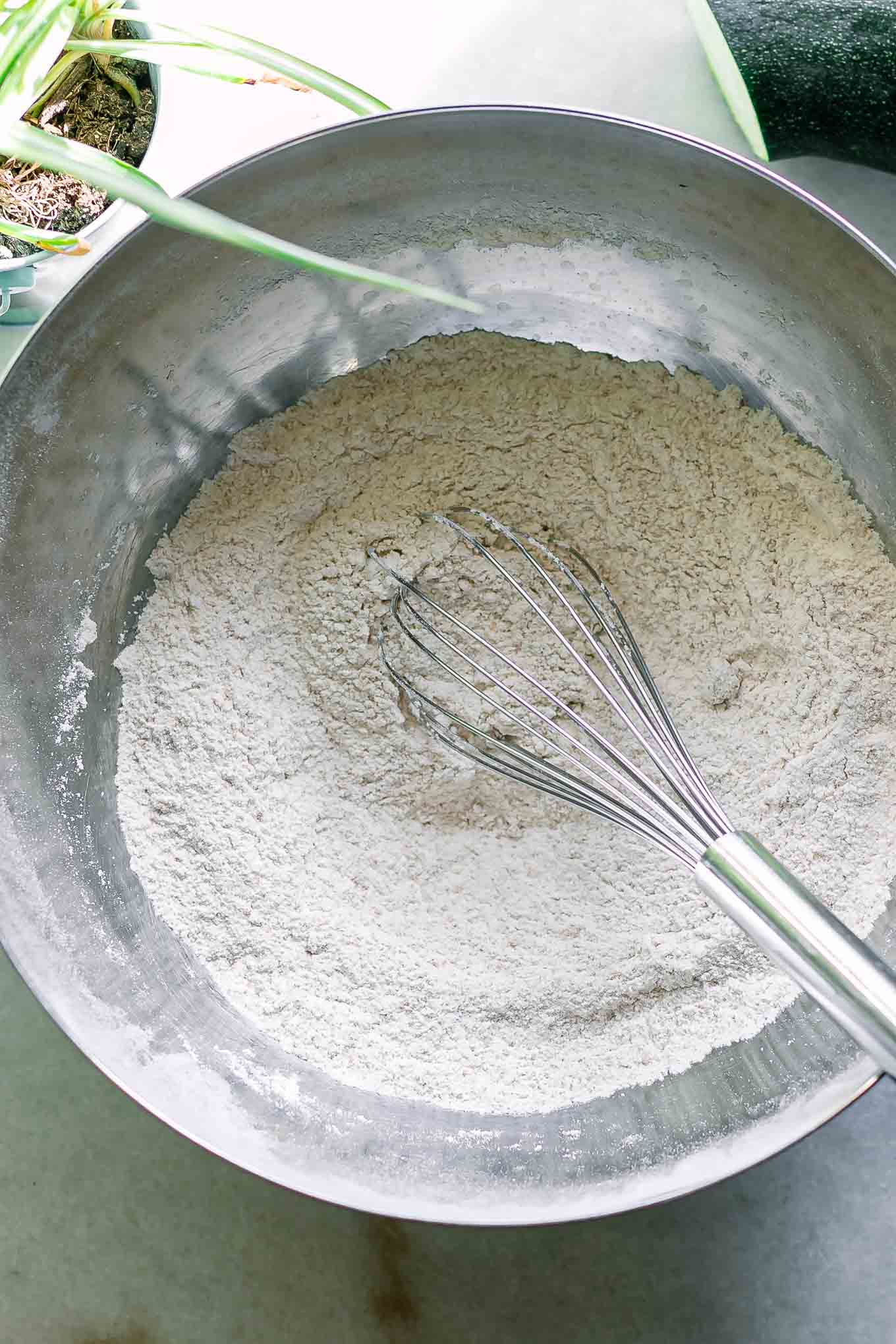 a mixing bowl with flour and other dry ingredients with a whisk