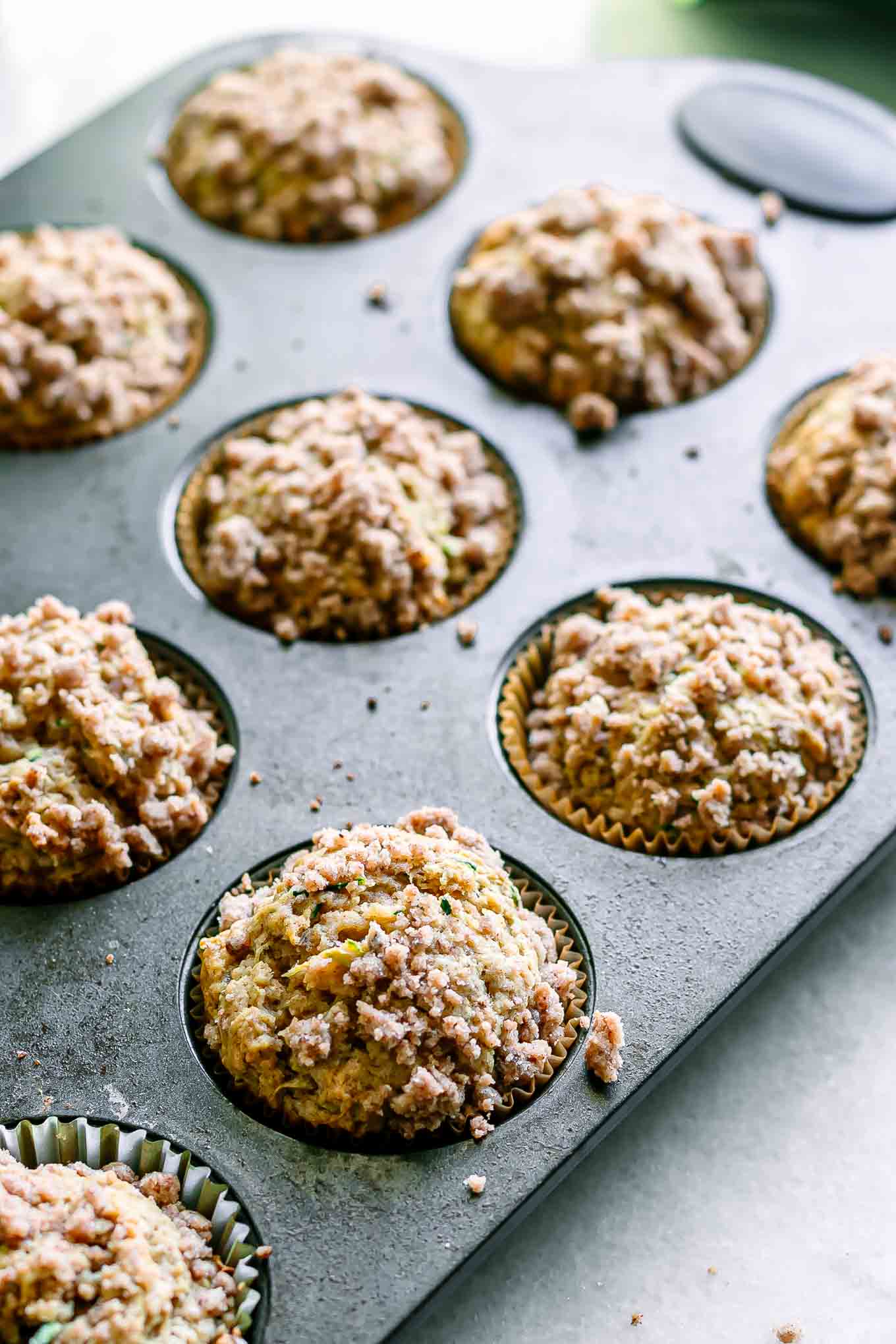a muffin tin with baked zucchini muffins