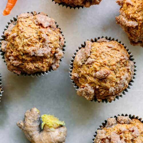 carrot cake muffins with a ginger brown sugar crumble on top on a white table