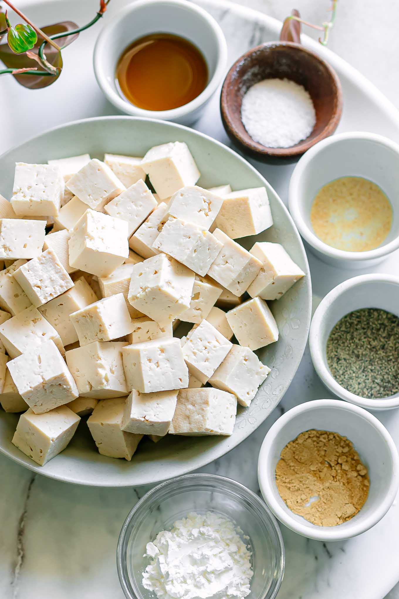 bowls of tofu, oil, salt, pepper, and spices for baking tofu