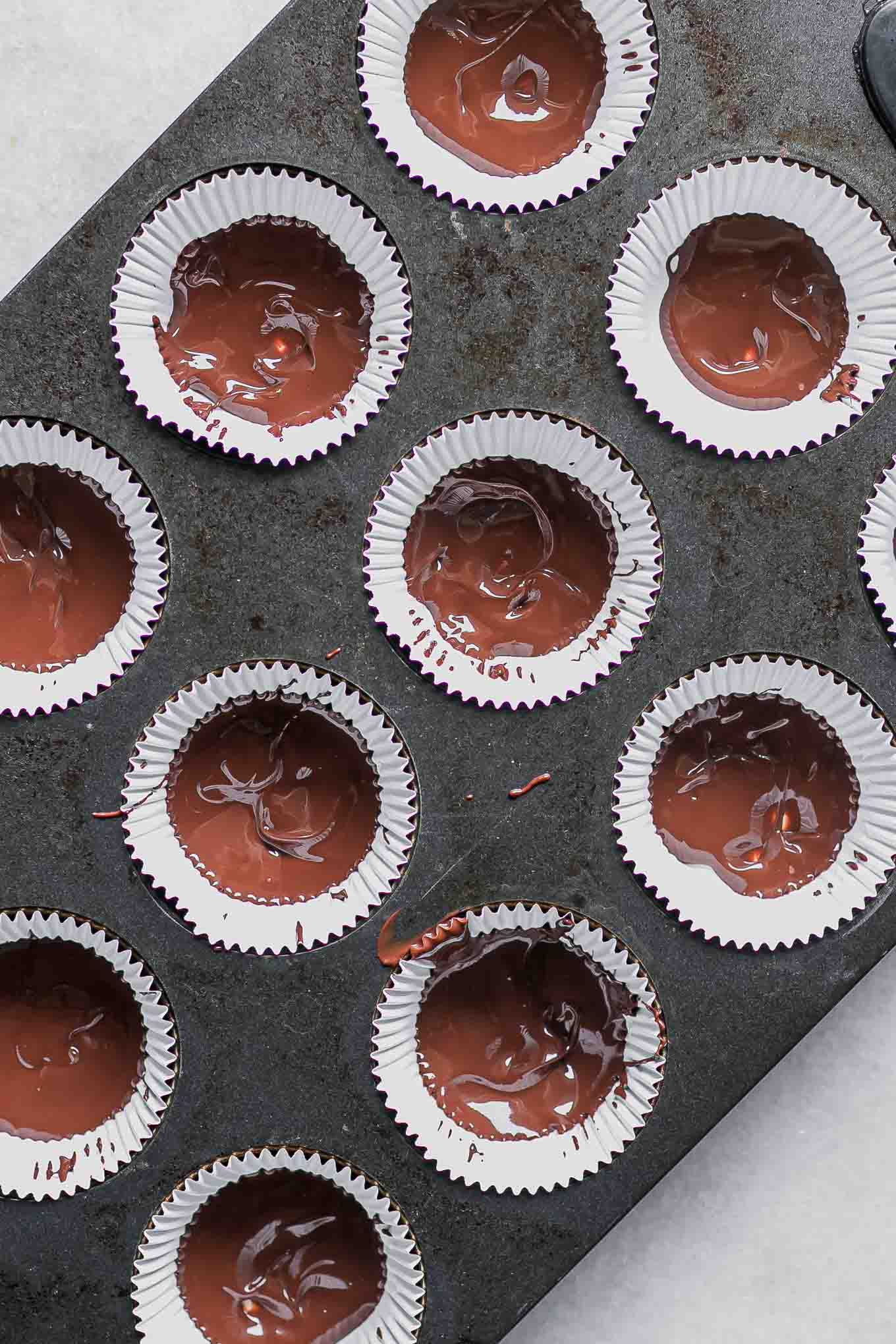 dark chocolate inside muffin liners in a muffin tin