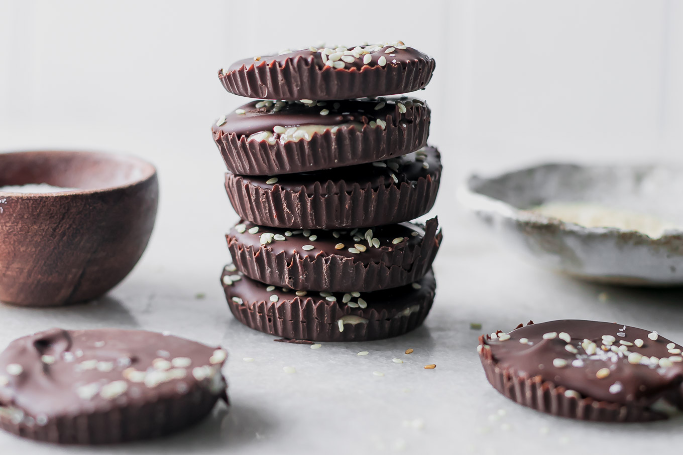 a stack of dark chocolate tahini cups on a white table