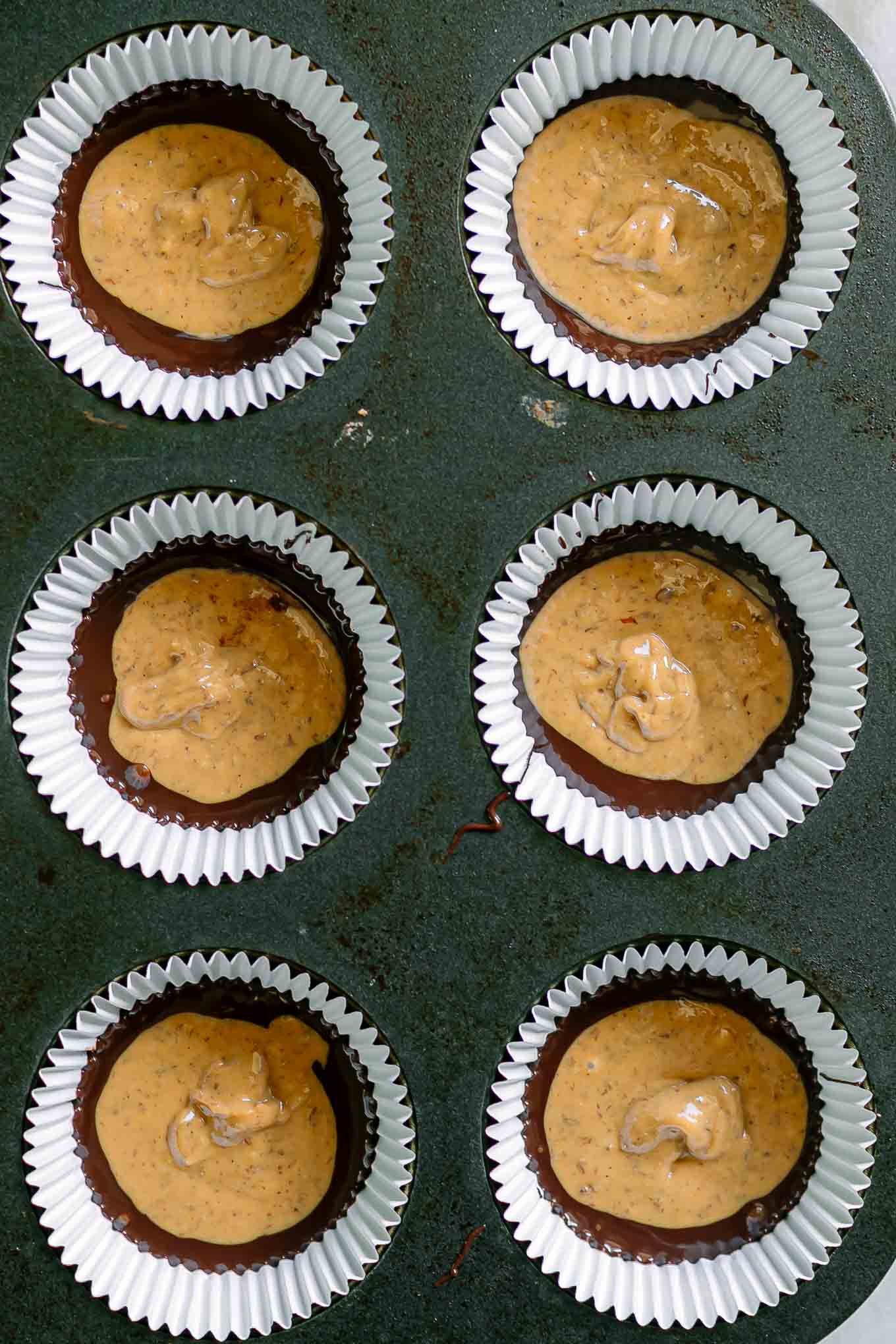 chocolate and peanut butter in a muffin tin for cups