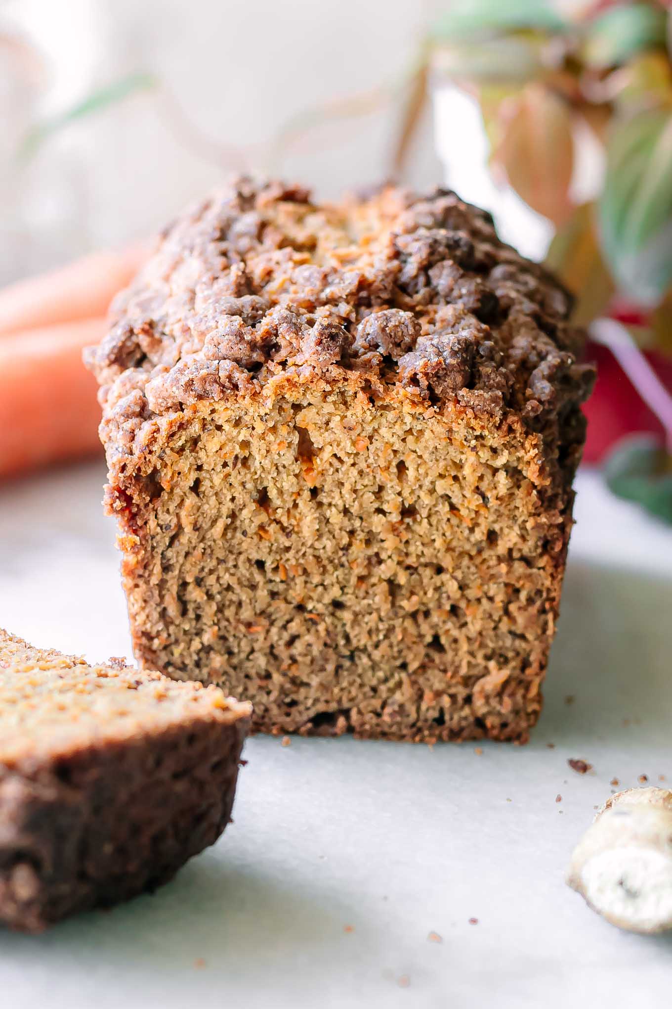 a loaf of carrot cake bread on a white table with cut slices