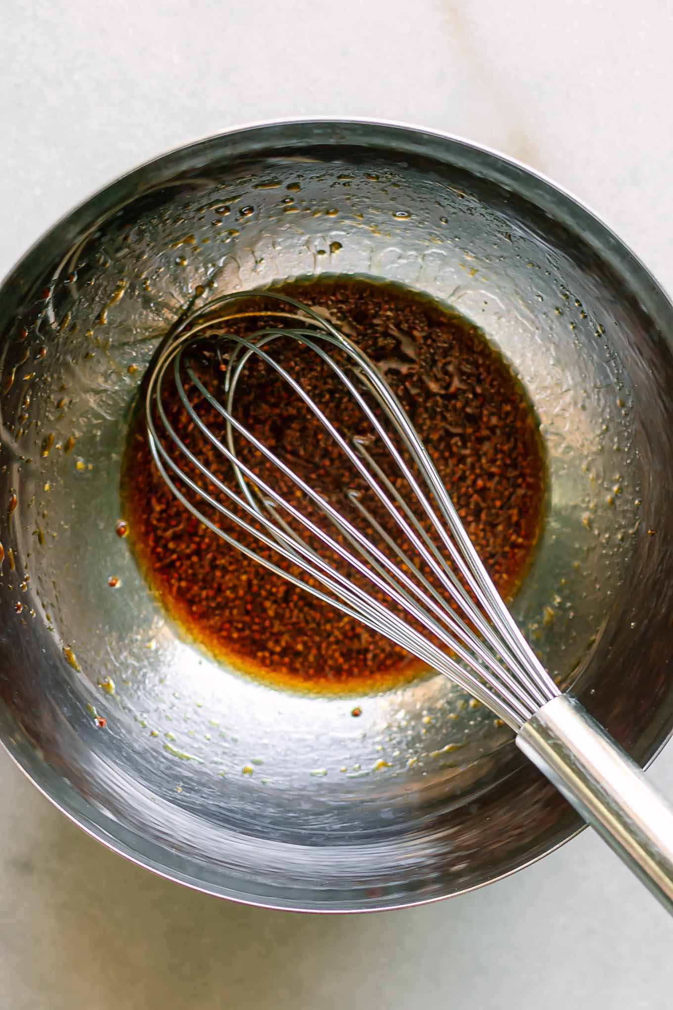 maple soy dressing in a mixing bowl with a whisk