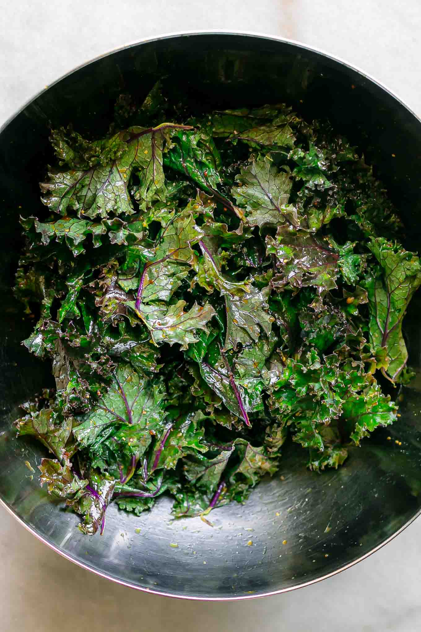 kale in a mixing bowl on a white table