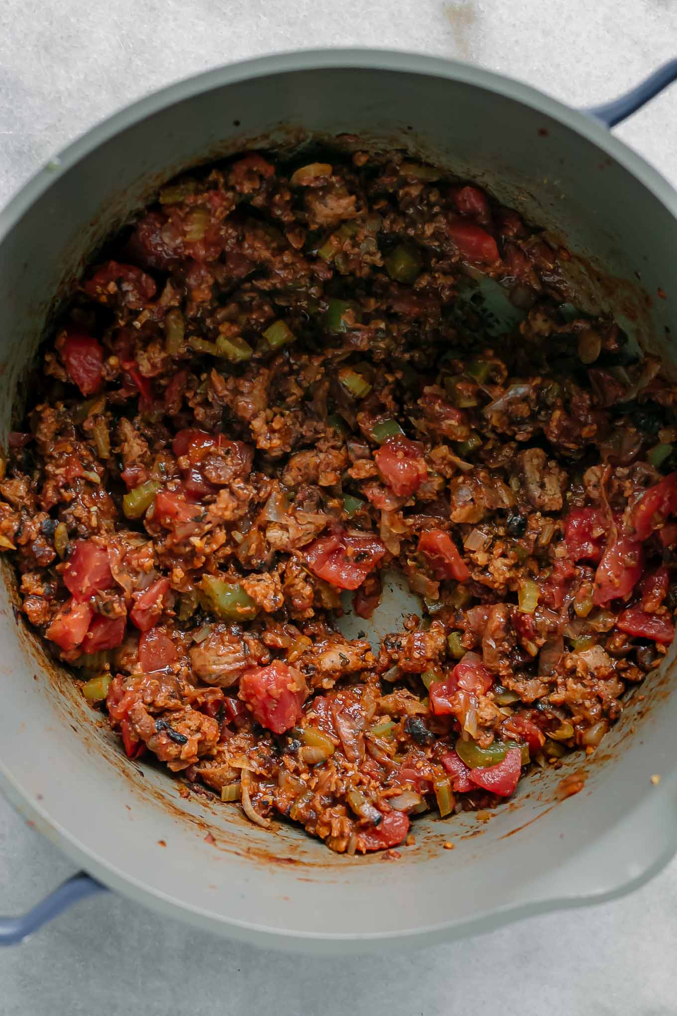 cooked vegan sausages with vegetables and spices in a pot