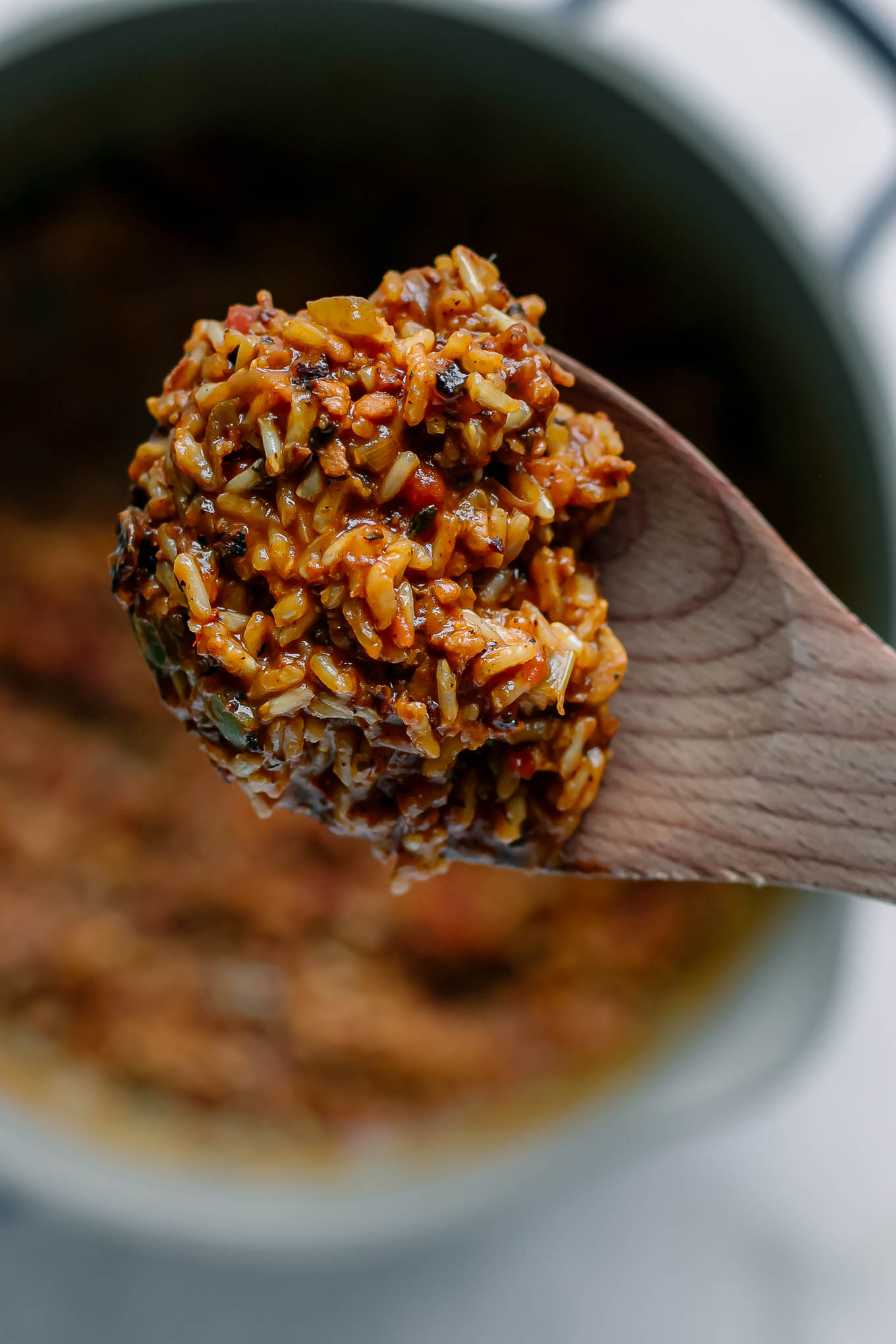 vegan jamabalaya on a wooden spoon over a pot