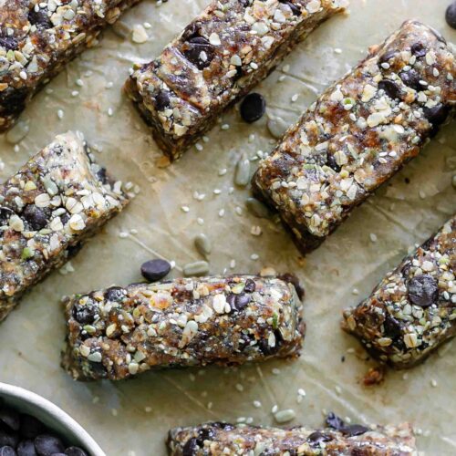 cut homemade snack bars made with tahini, rolled oats, seeds, chocolate, and dates