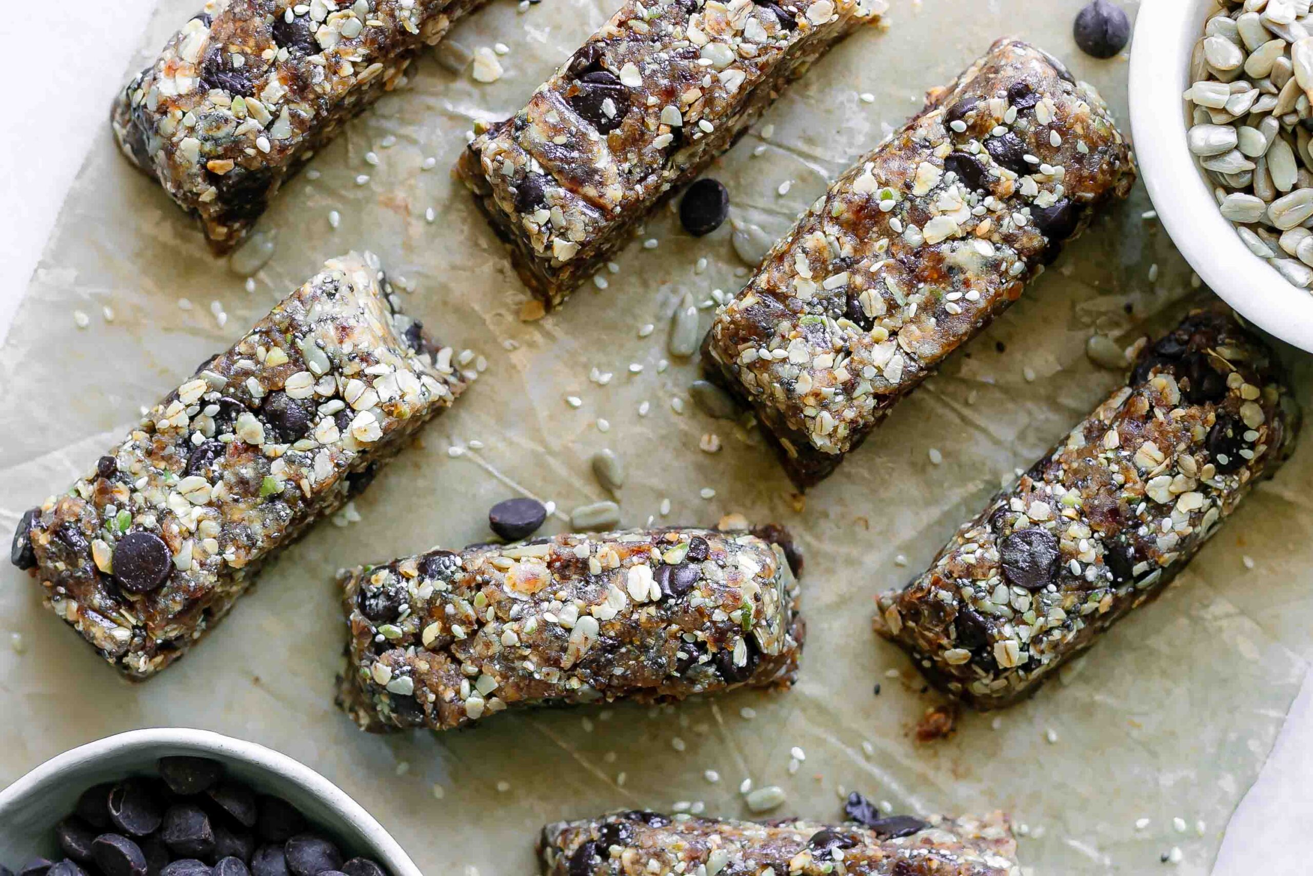 cut homemade snack bars made with tahini, rolled oats, seeds, chocolate, and dates