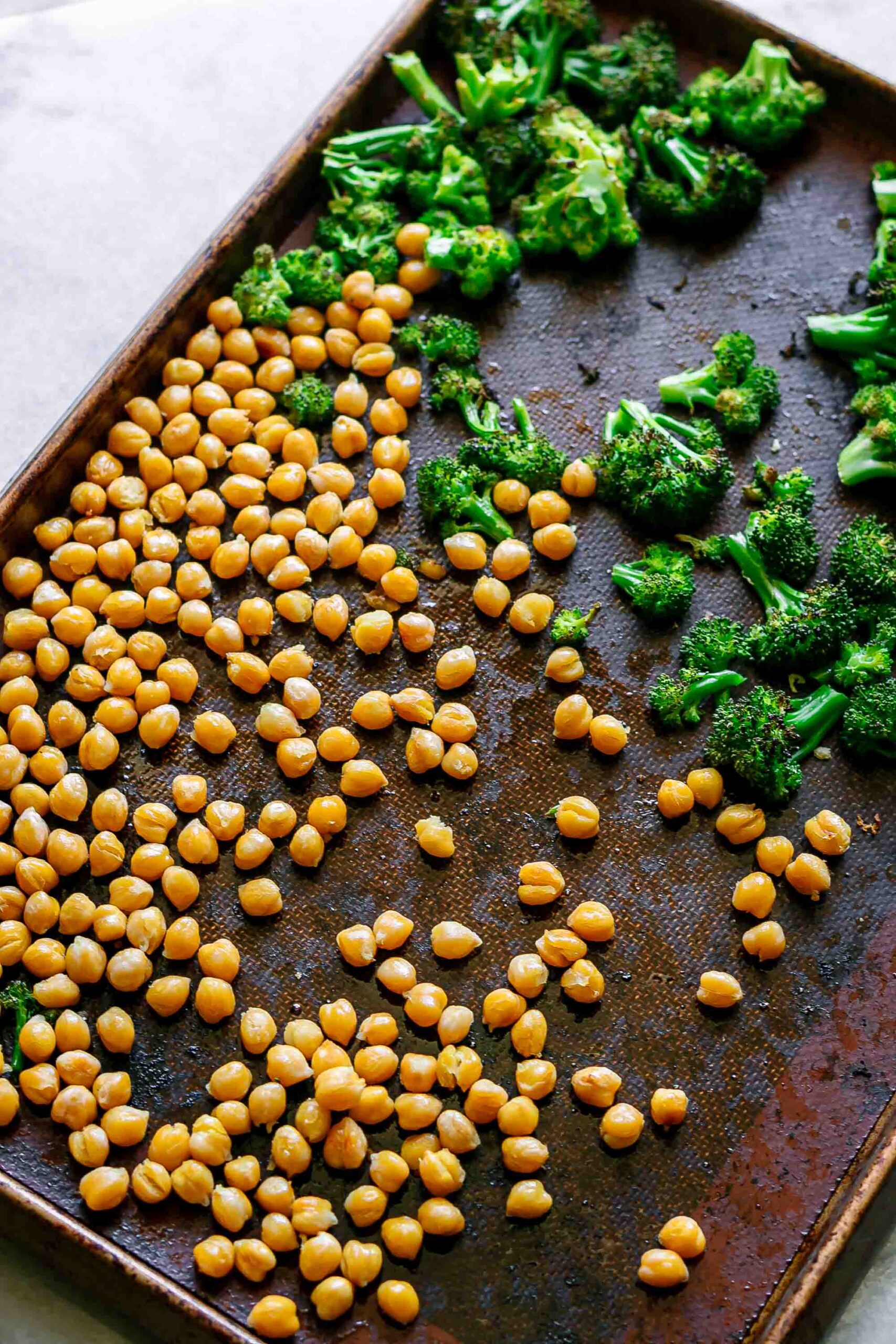 roasted broccoli and chickpeas on a baking sheet after coming out of the oven