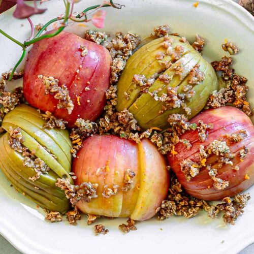 baked hasselback apples on a plate and stuffed with homemade granola