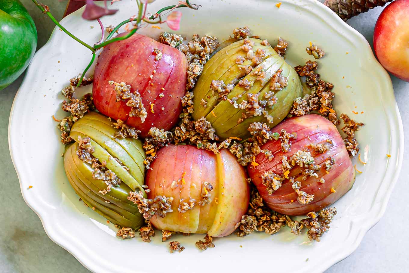 baked hasselback apples on a plate and stuffed with homemade granola
