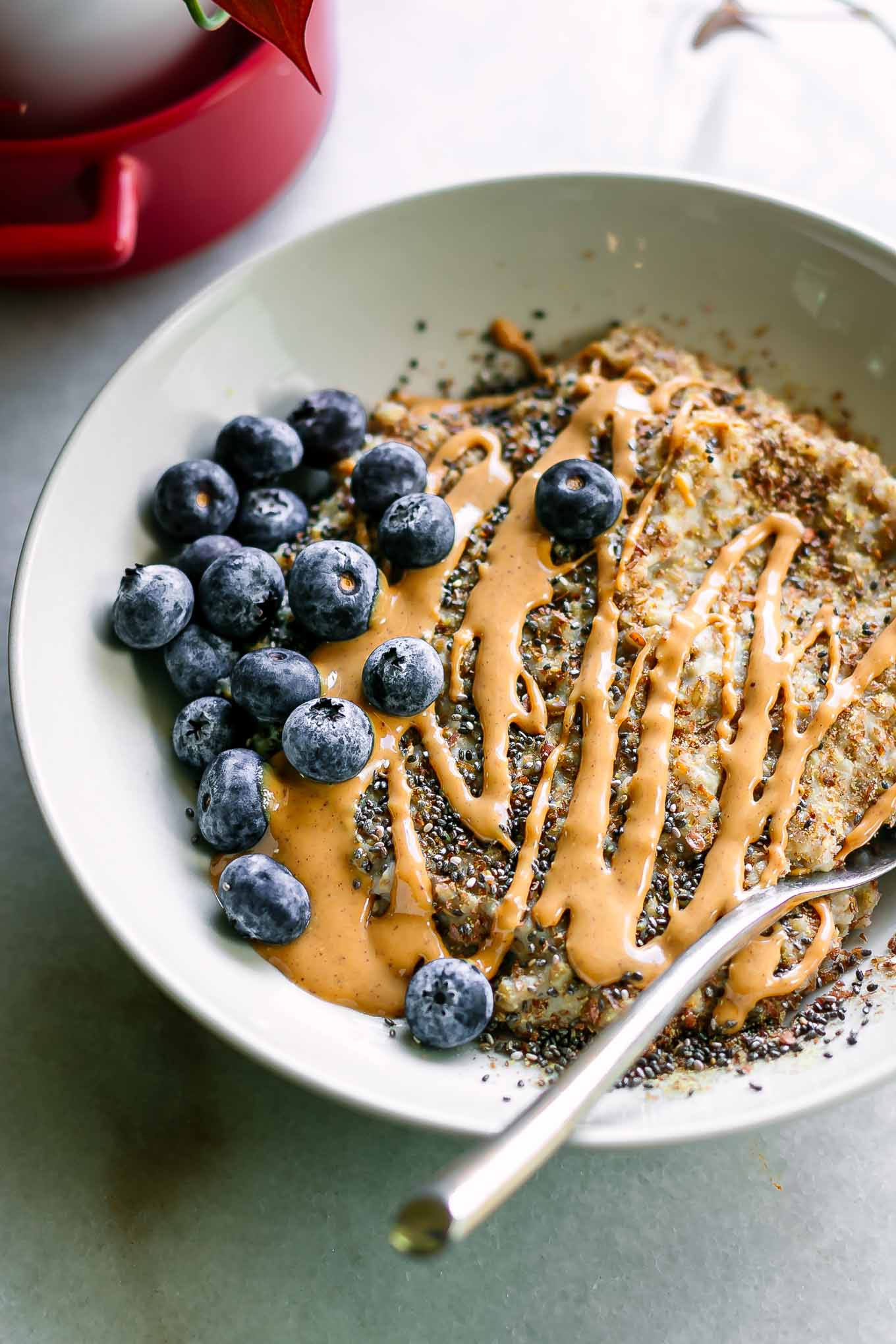 an oatmeal bowl with blueberries, peanut butter, flax seeds, and chia seeds