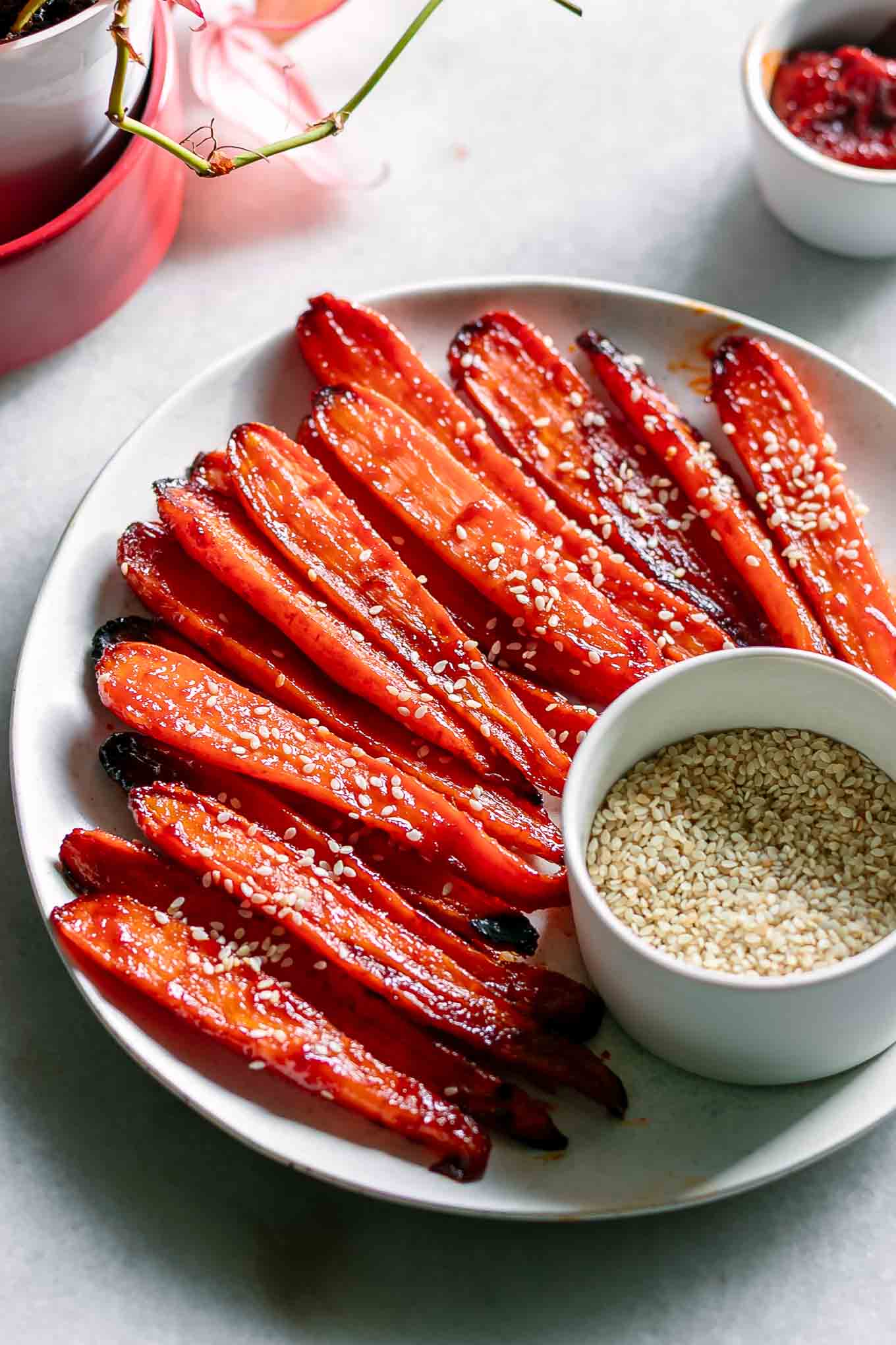 sliced roasted carrots garnished with sesame seeds on a plate