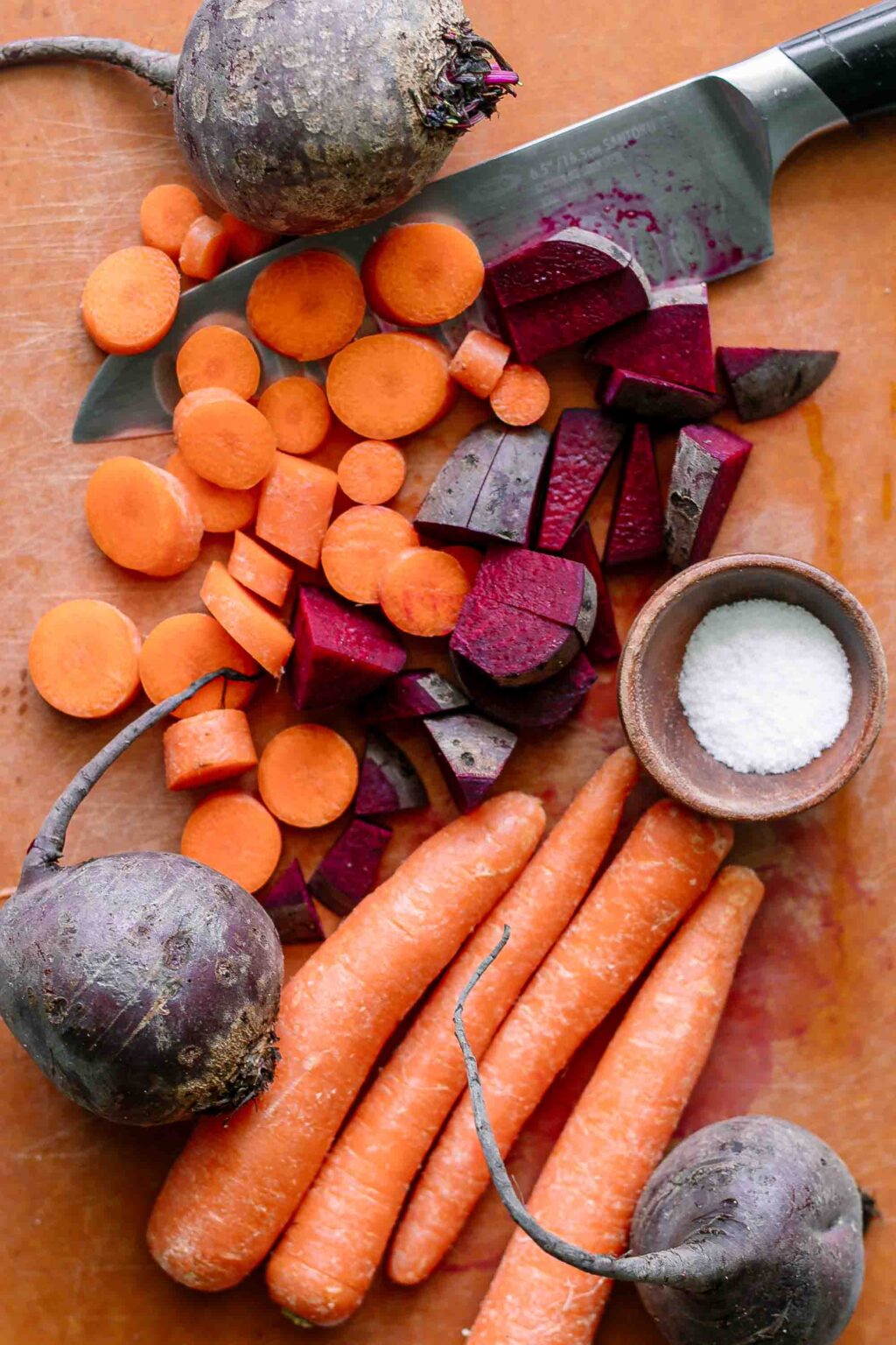 cut carrots and beets on a cutting board with a knife